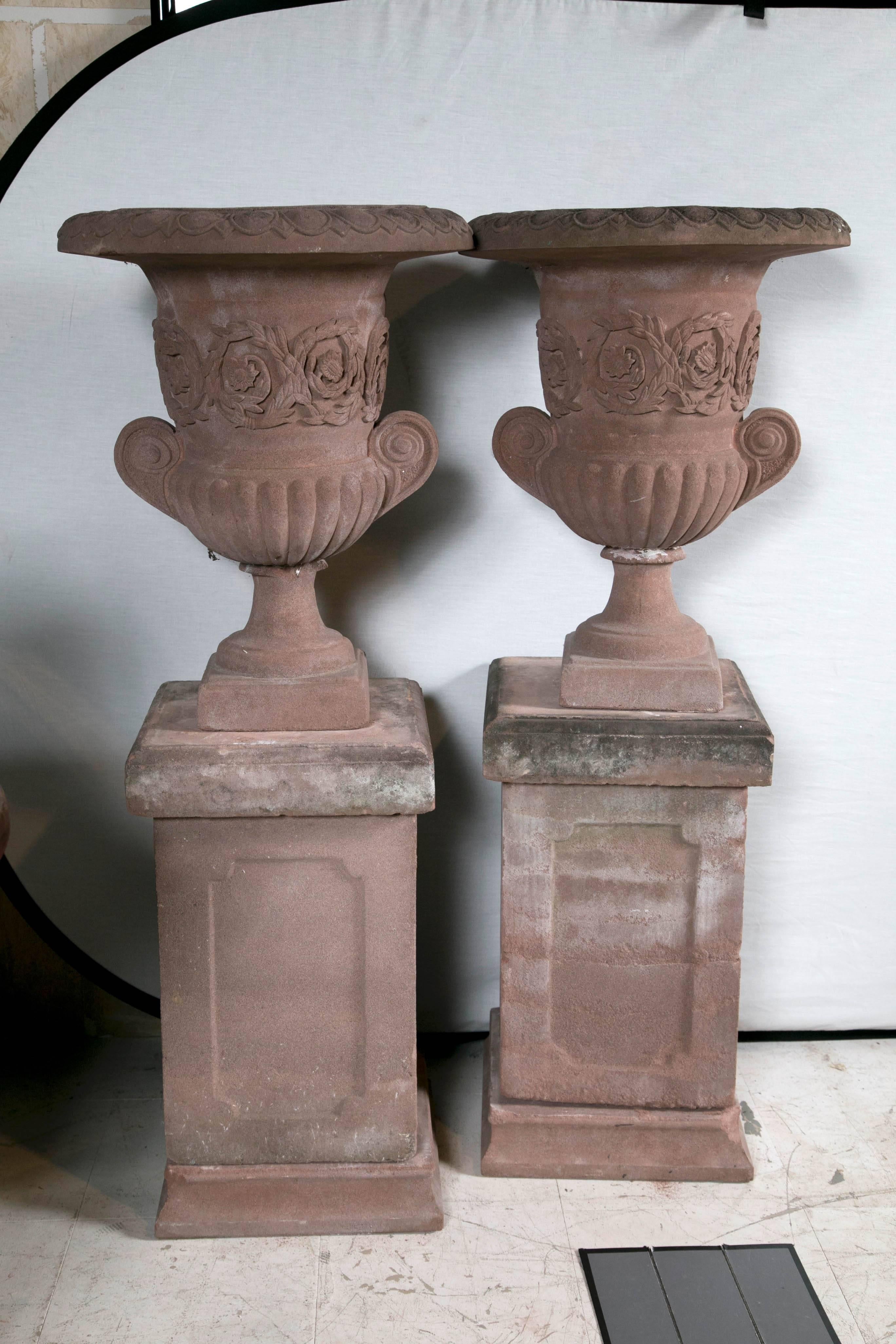 Lovely pair of English terra cotta garden urns on matching plinths.