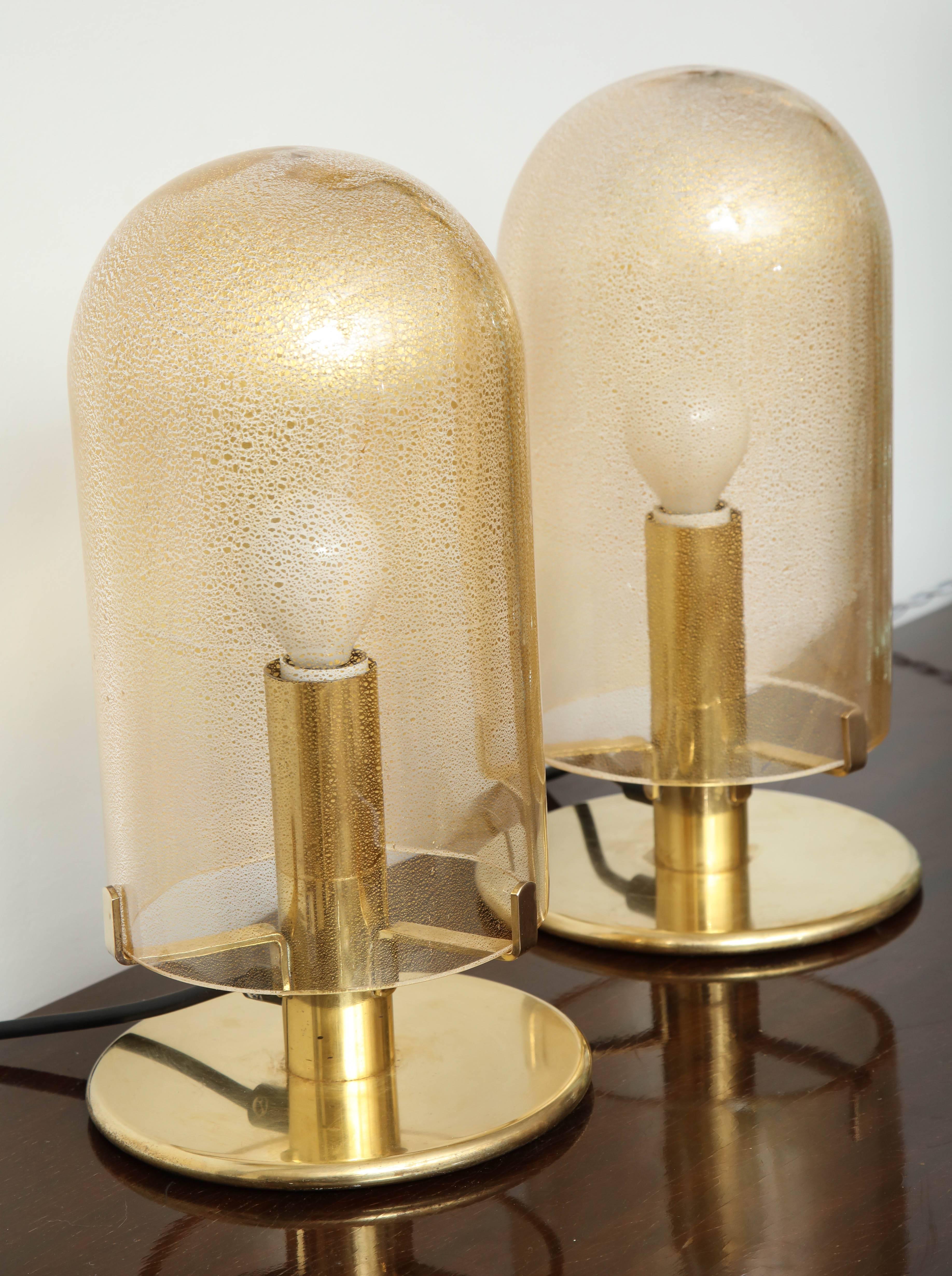 Pair of Seguso table lamps made in Venice 1970, two blown glass shades with gold fleck fused into the glass resting on three arms on a modernist brass base, great quality, takes one E14 bulb.
 