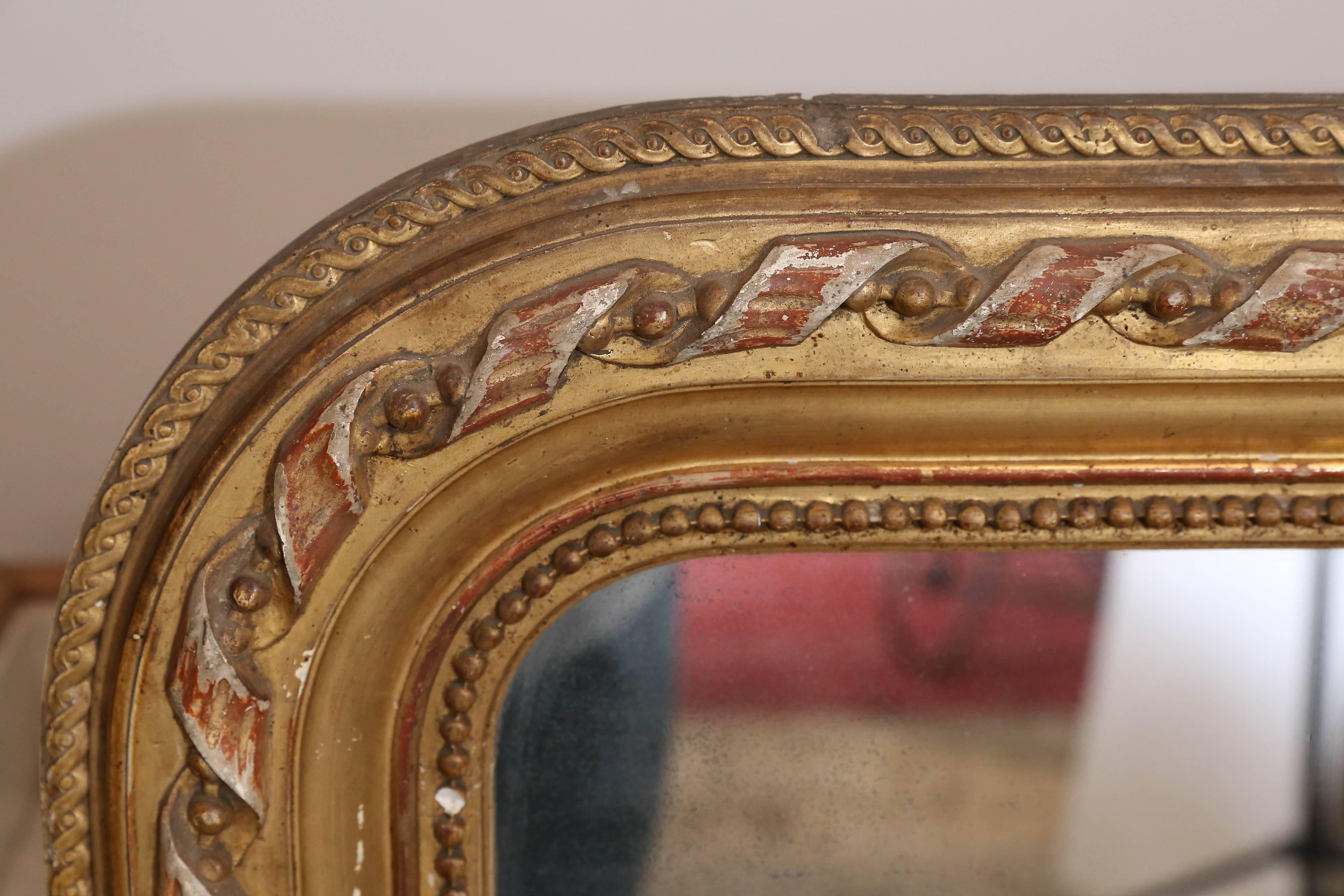 Antique French Louis Philippe mirror discovered during our recent time in France with lovely carved ribbon detail and distressed gilt finish. Measures 47