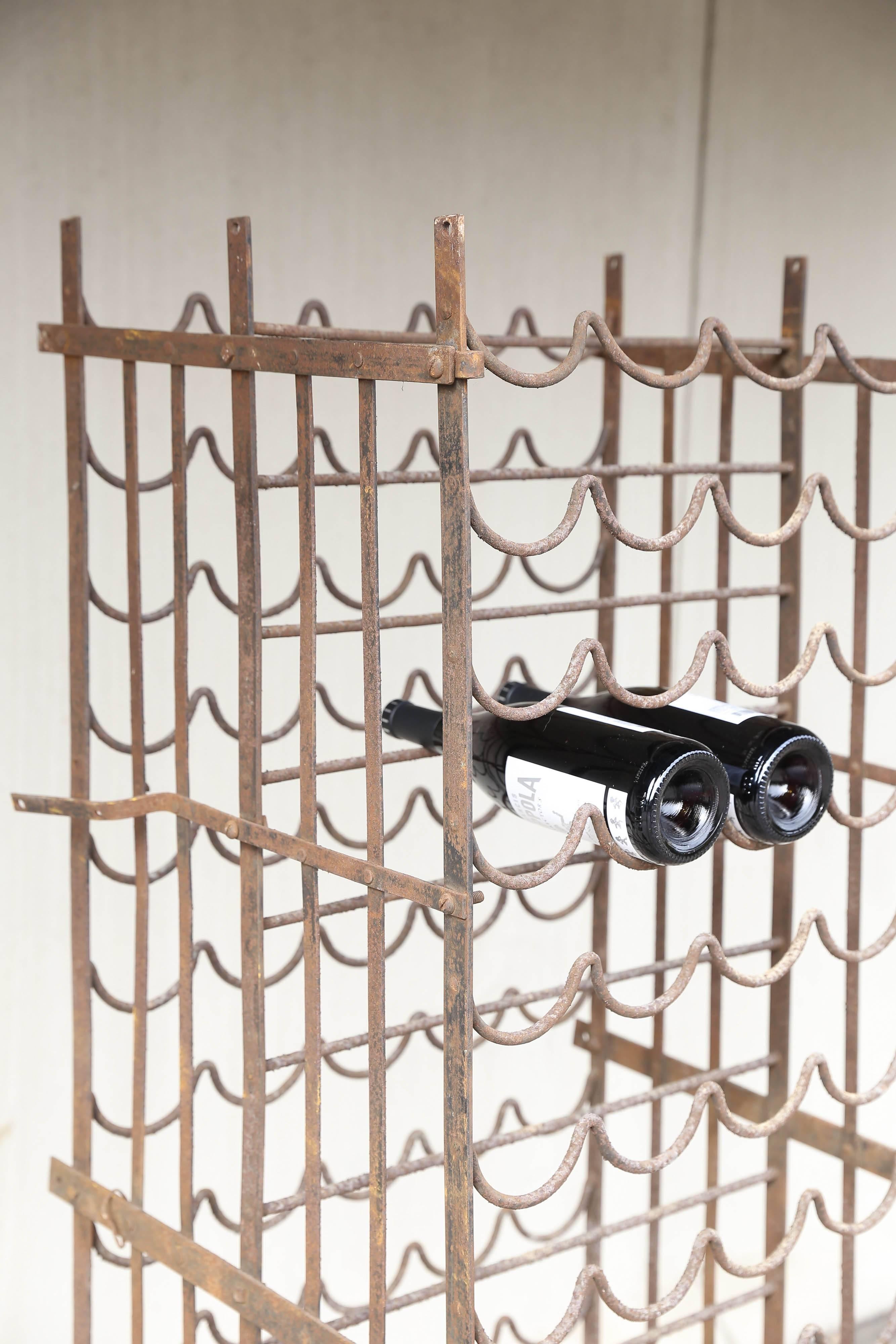 Antique French iron wine rack with door discovered during our recent time in France. Holds multiple bottles in both the front and the rear and can be mounted to the wall or floor and is lockable. Given its age and use, it's heavily distressed with