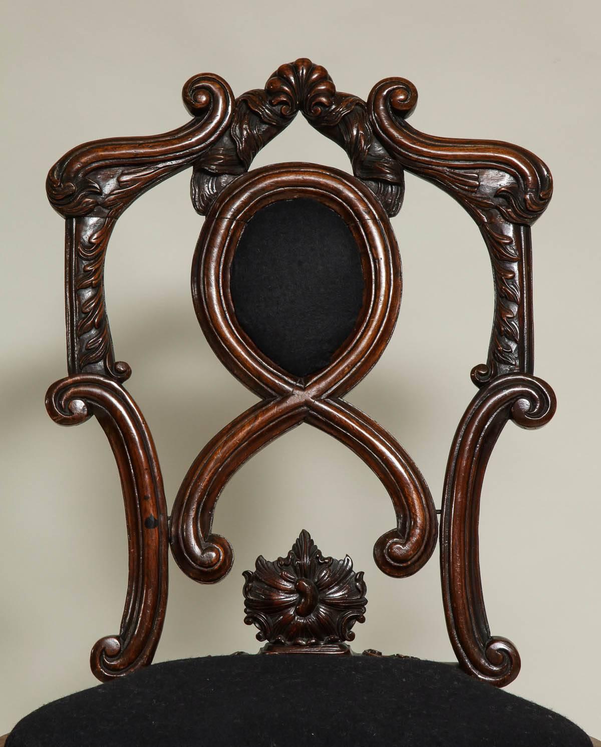 Bold 18th century Portuguese period side chair with scroll and stylized lion tail carving, the upholstered balloon seat over scrolled and outward rolled apron, standing on boldly carved lion paw feet with curly hair, the whole constructed of solid