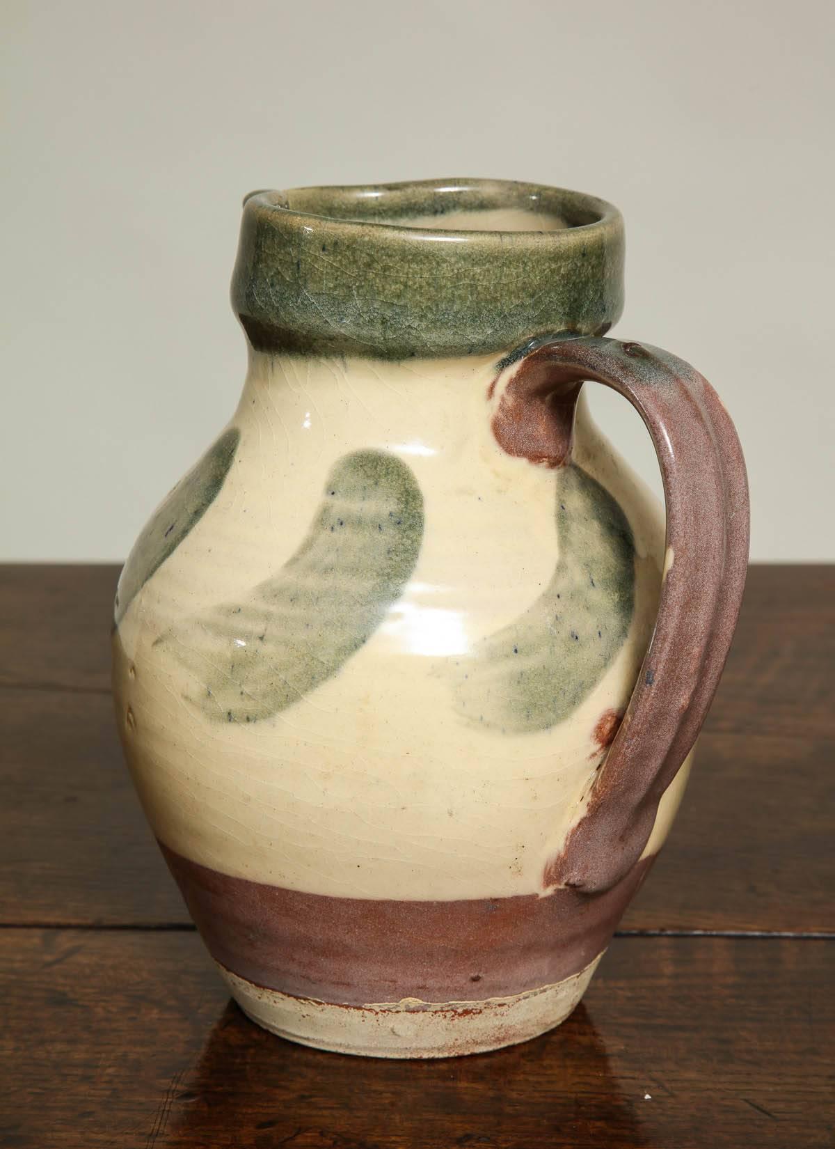Fine English Wattisfield Studio Pottery pitcher with green rim and brush decoration and plum handle. The Wattisfield Pottery has been active since its foundation toppin the beginning of the 19th century and was a popular site for pottery since pre