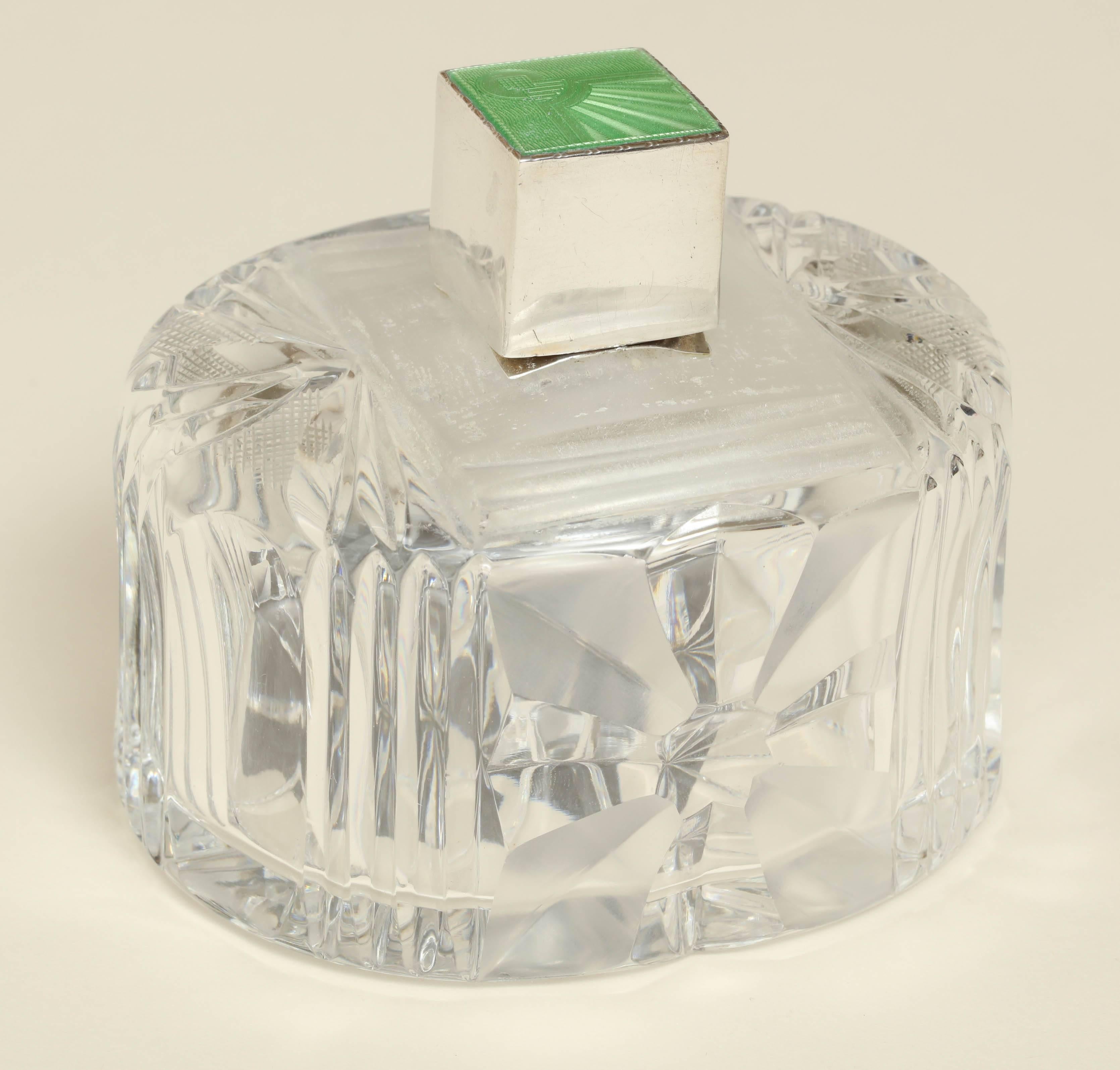 With elaborately cut crystal body and a sterling silver screw top with green guilloche enamel on top; missing glass stopper.

Impressed for 925 silver/ Birmingham/ 1935/ A C.
 
