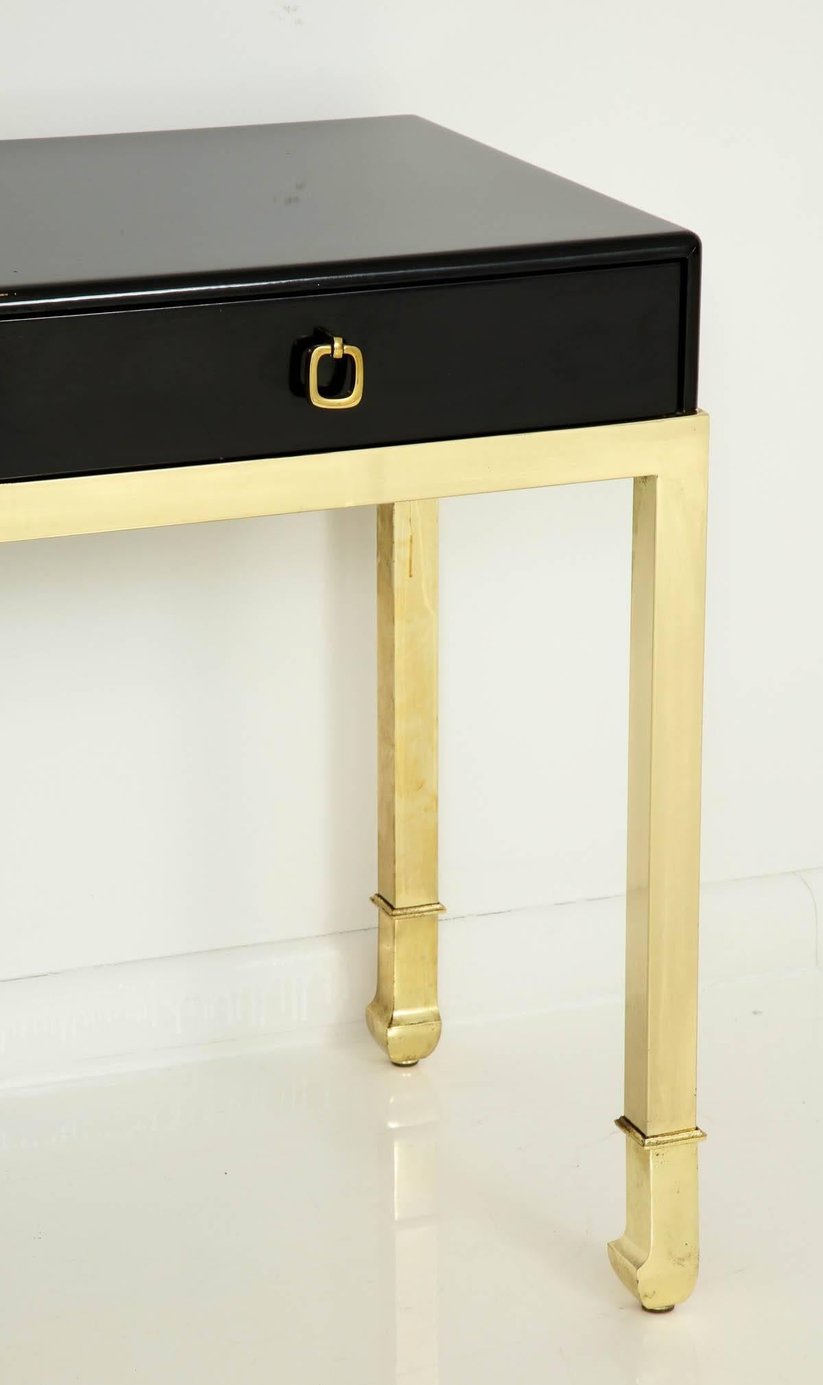 Elegant 1980s Design Institute of America console/desk.
It retains the original high gloss black lacquer finish with brass legs and hardware and it is in great condition with minimal age appropriate wear.
It could be used in a variety of ways such