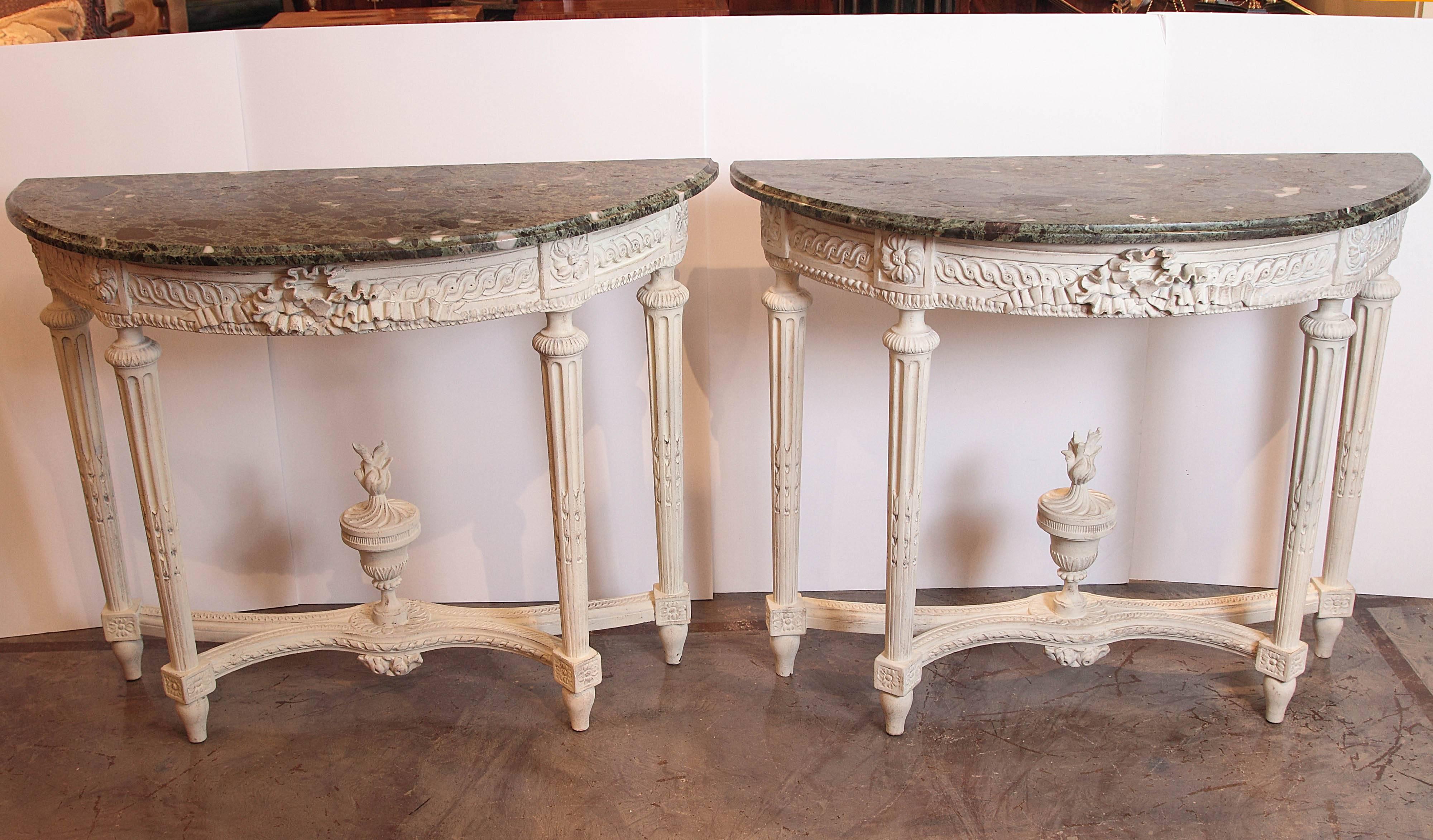 Finely carved pair of 19th century French Louis XVI crème painted marble top consoles.