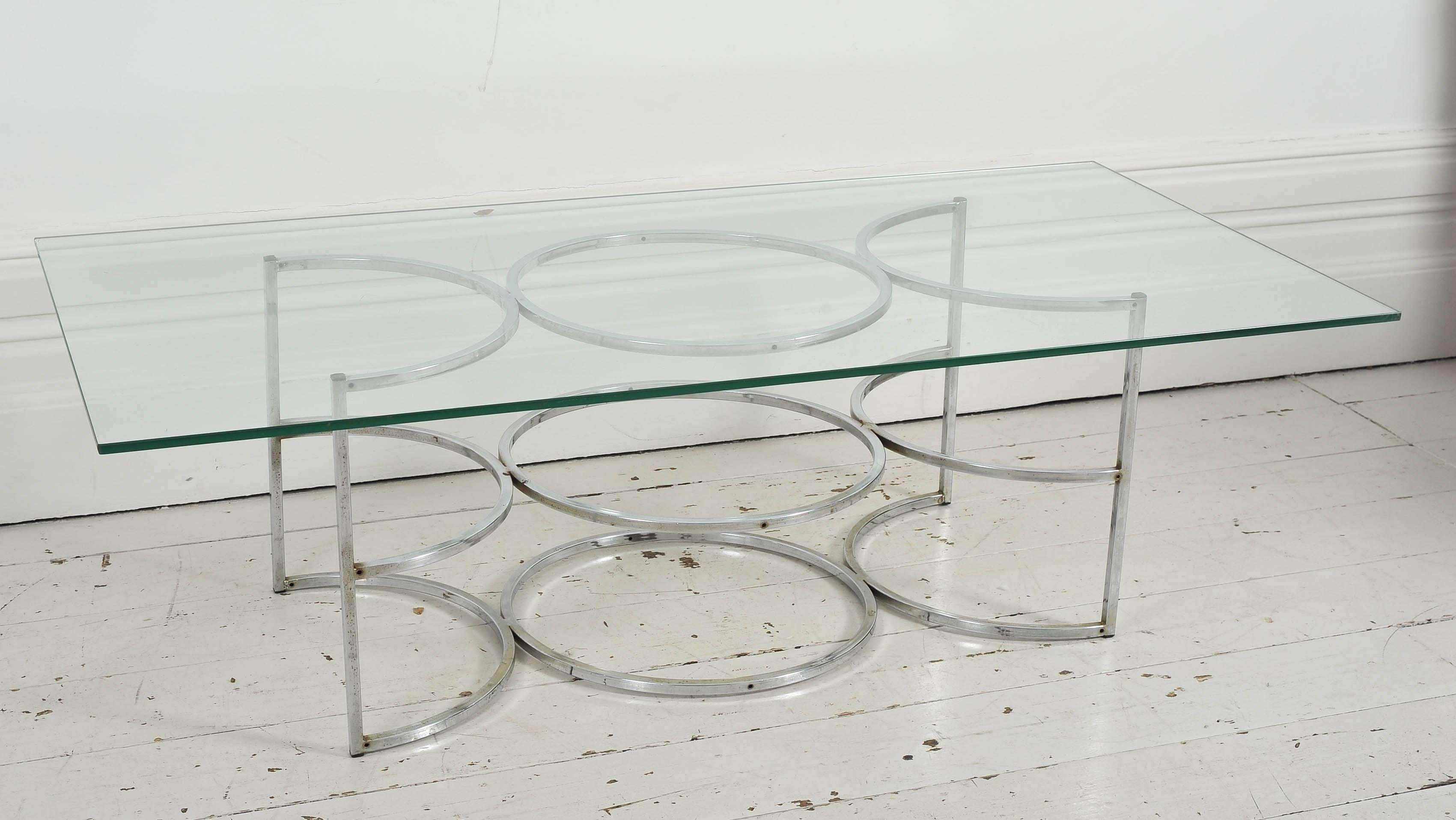This is a lovely 1960's French coffee table with it's clean lines and slick design.   The base is chromed metal in a circular design. The glass top is original. 
In good vintage condition with minor pitting to base.