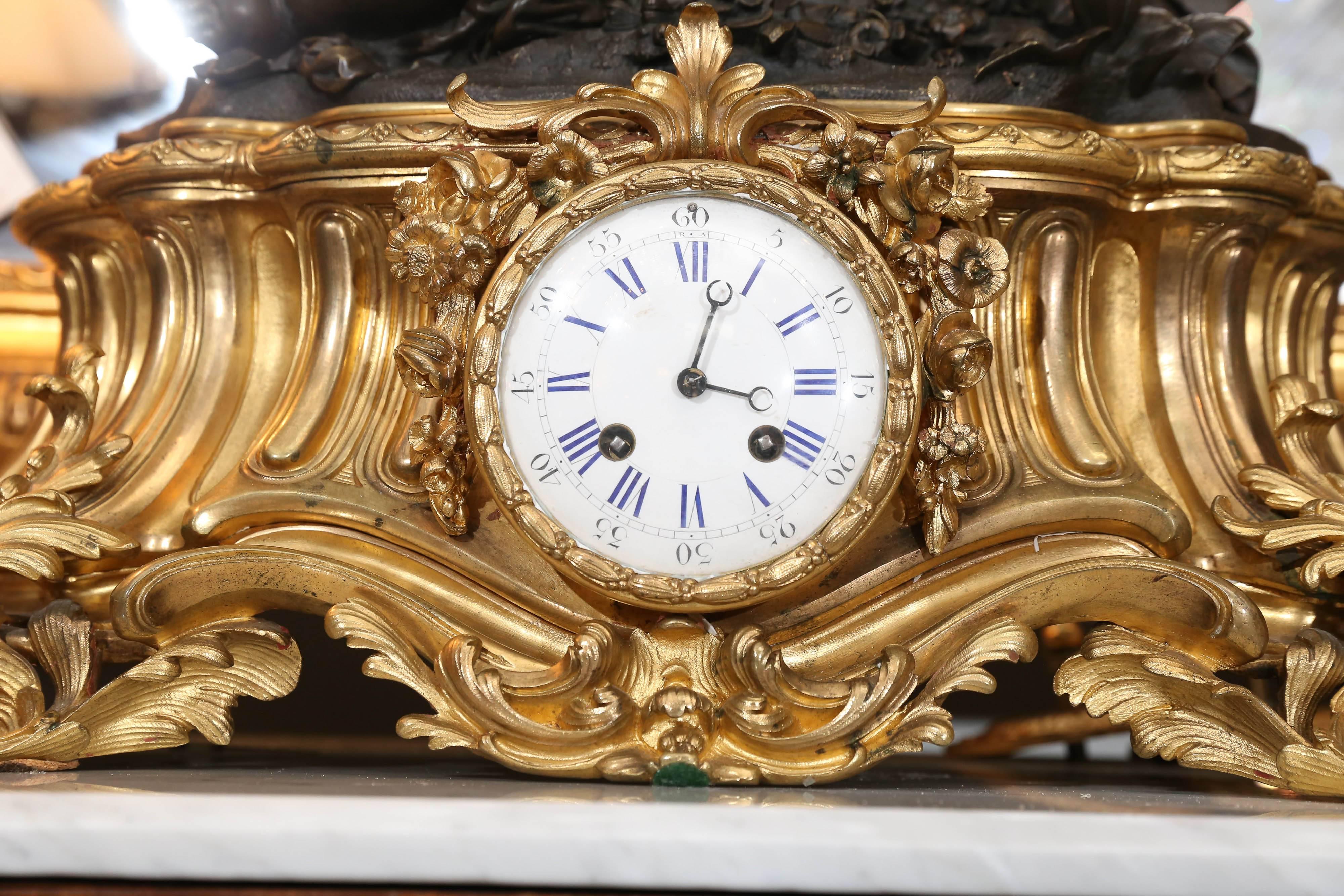 Lovely and large clock depicting a playful putti resting on top of a gilt
bronze base. The putti is reaching for a butterfly amidst a group of flowers
the clock has a white enamel face with blue numerals. It is in working
Order and had the