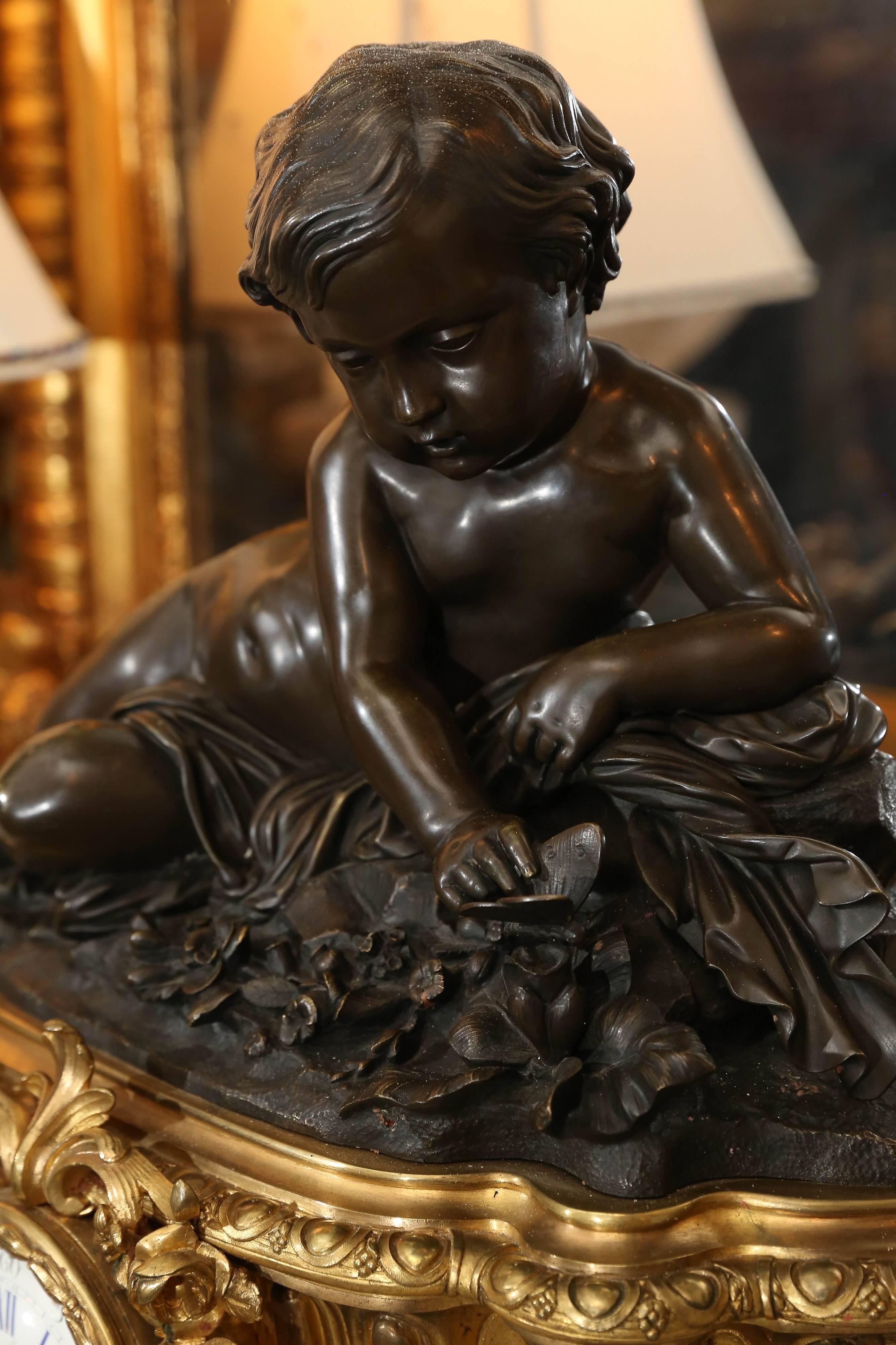 XIXe siècle Grande horloge en bronze doré du 19ème siècle avec putto patiné monté sur le dessus en vente