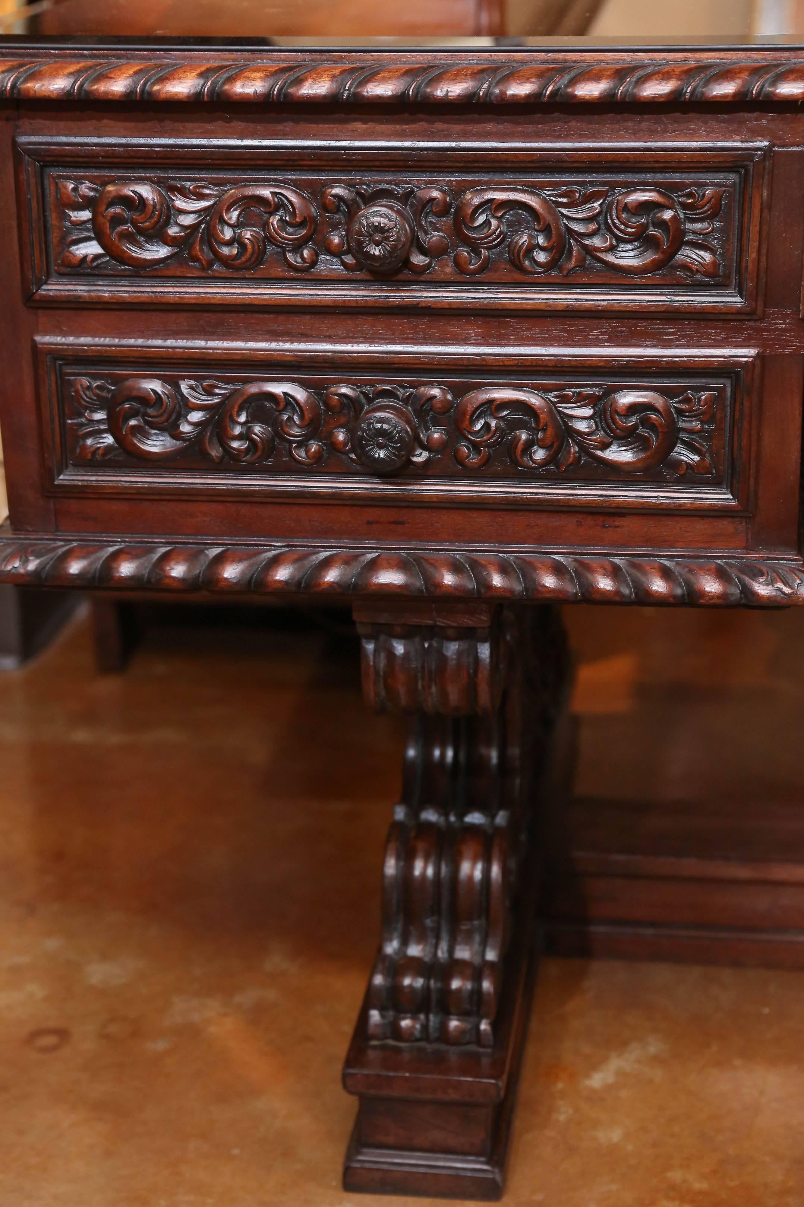 Incredible carved wood desk in a rich mahogany, carved on all sides so
That it could be viewed from all directions. The drawers all slide easily
For a fully functional work place. A beveled glass top has been added
For making it resistant to