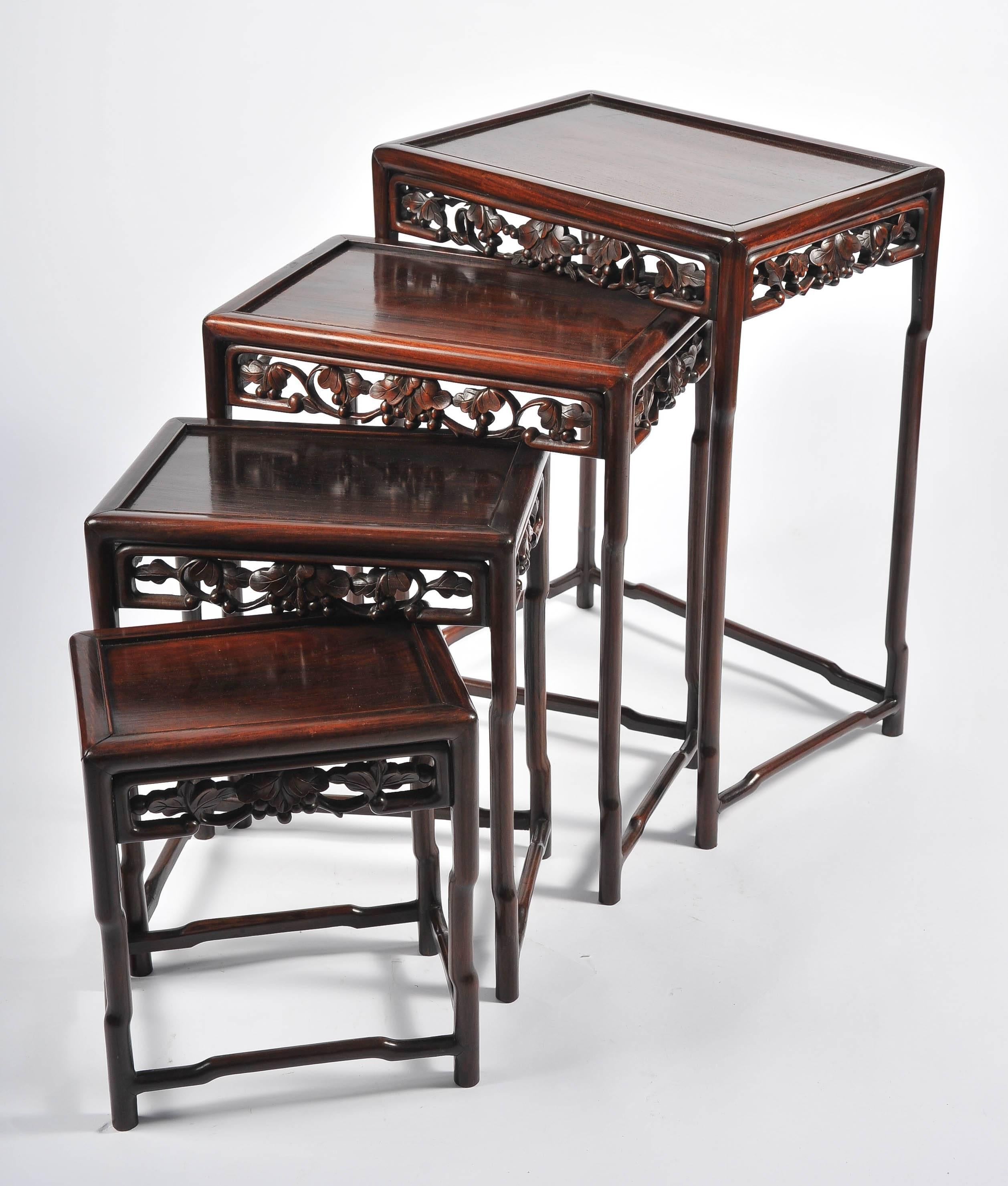 Un ensemble de quatre tables chinoises en bois dur de bonne qualité, datant du 19e siècle. La frise est ornée d'un décor de feuillage sculpté.