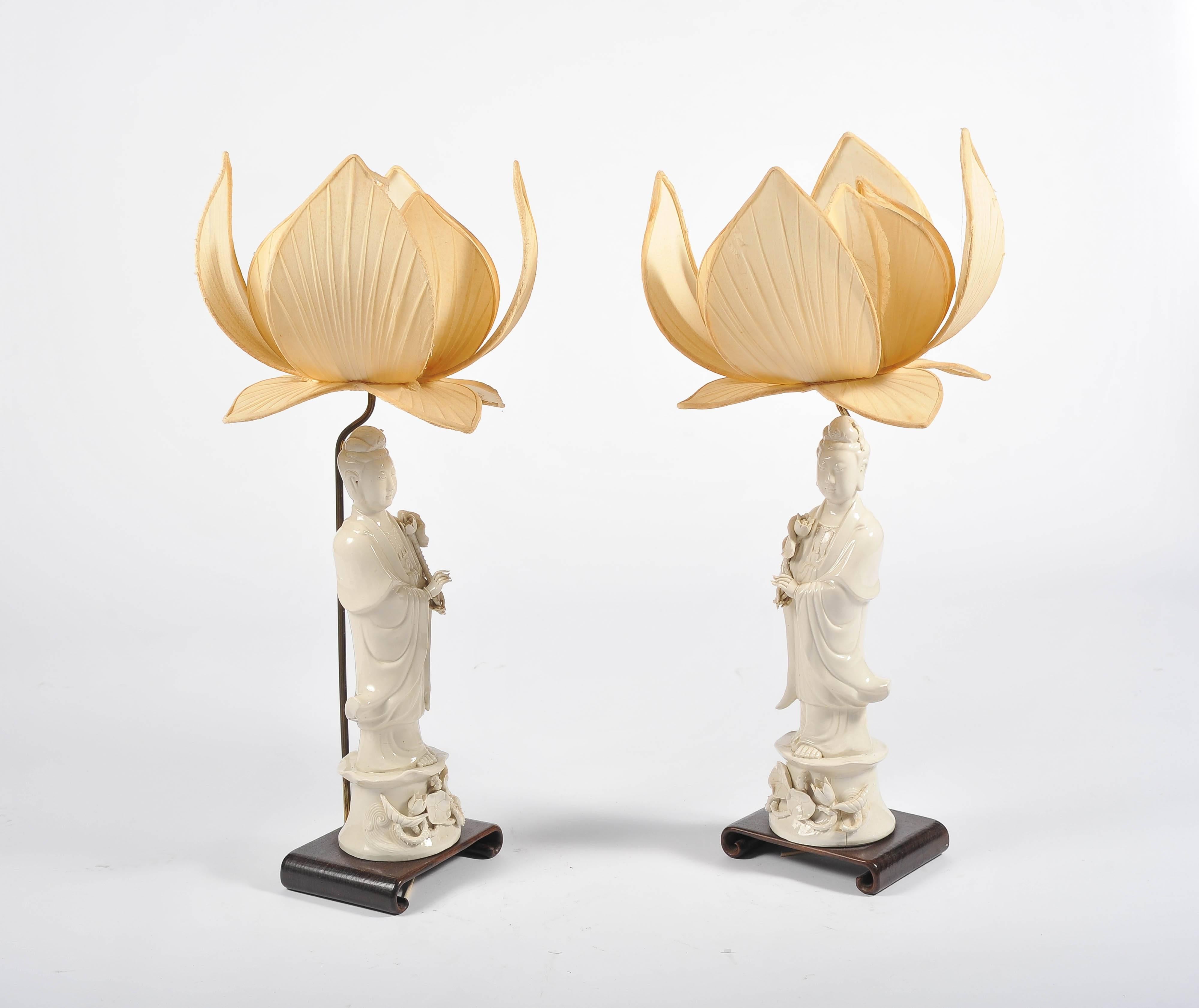 A very pleasing and decorative pair of Chinese Blanc de chine Guanyin lamps, each mounted on a scrolling hardwood base and lotus leaf style shades.
