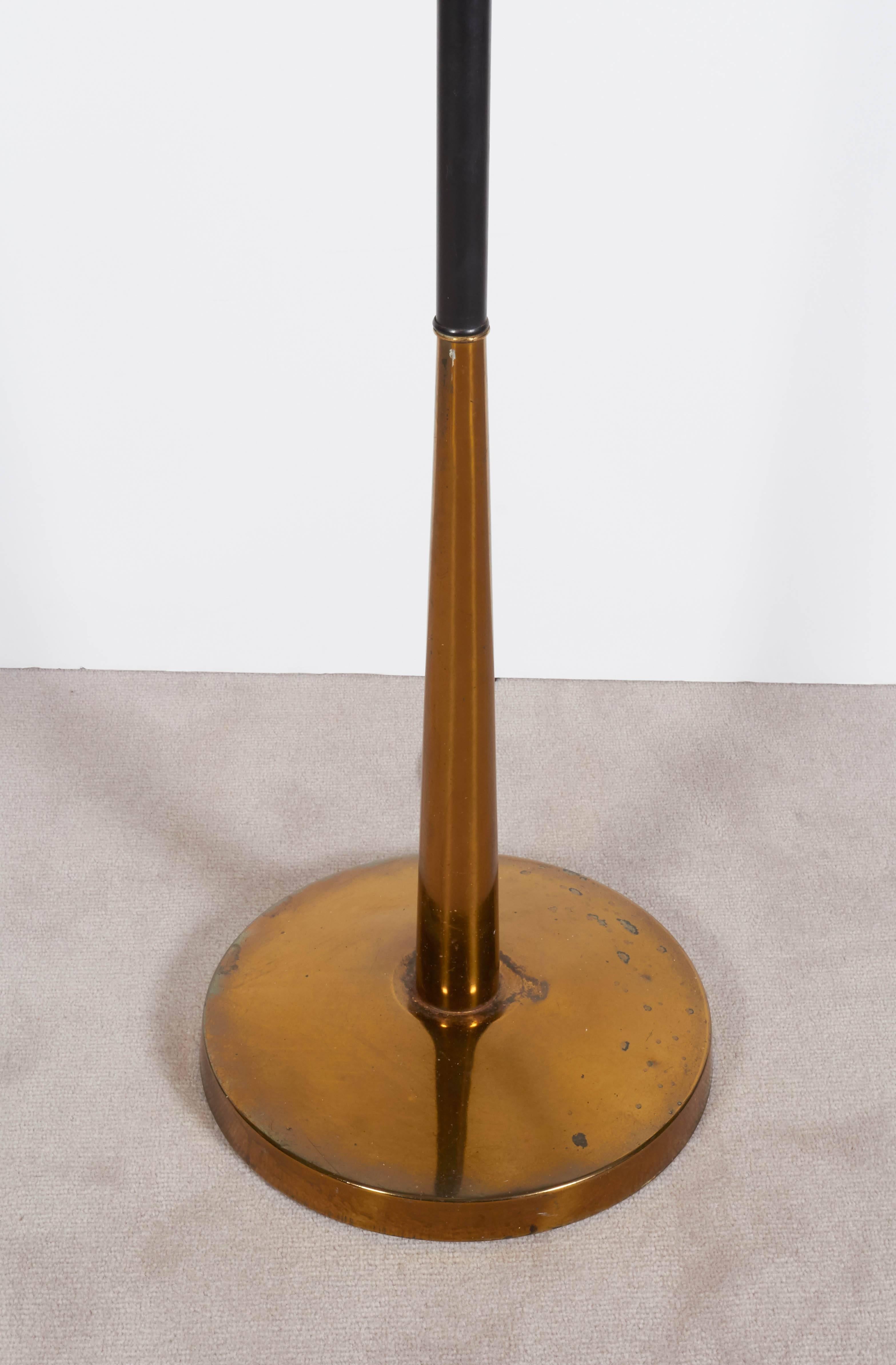 A Mid-Century era brass floor lamp, with tapered stem and accented with matte black enamel; includes milk glass diffuser shade. Very good vintage condition, with presence of age appropriate wear and patina to finish.

11082
