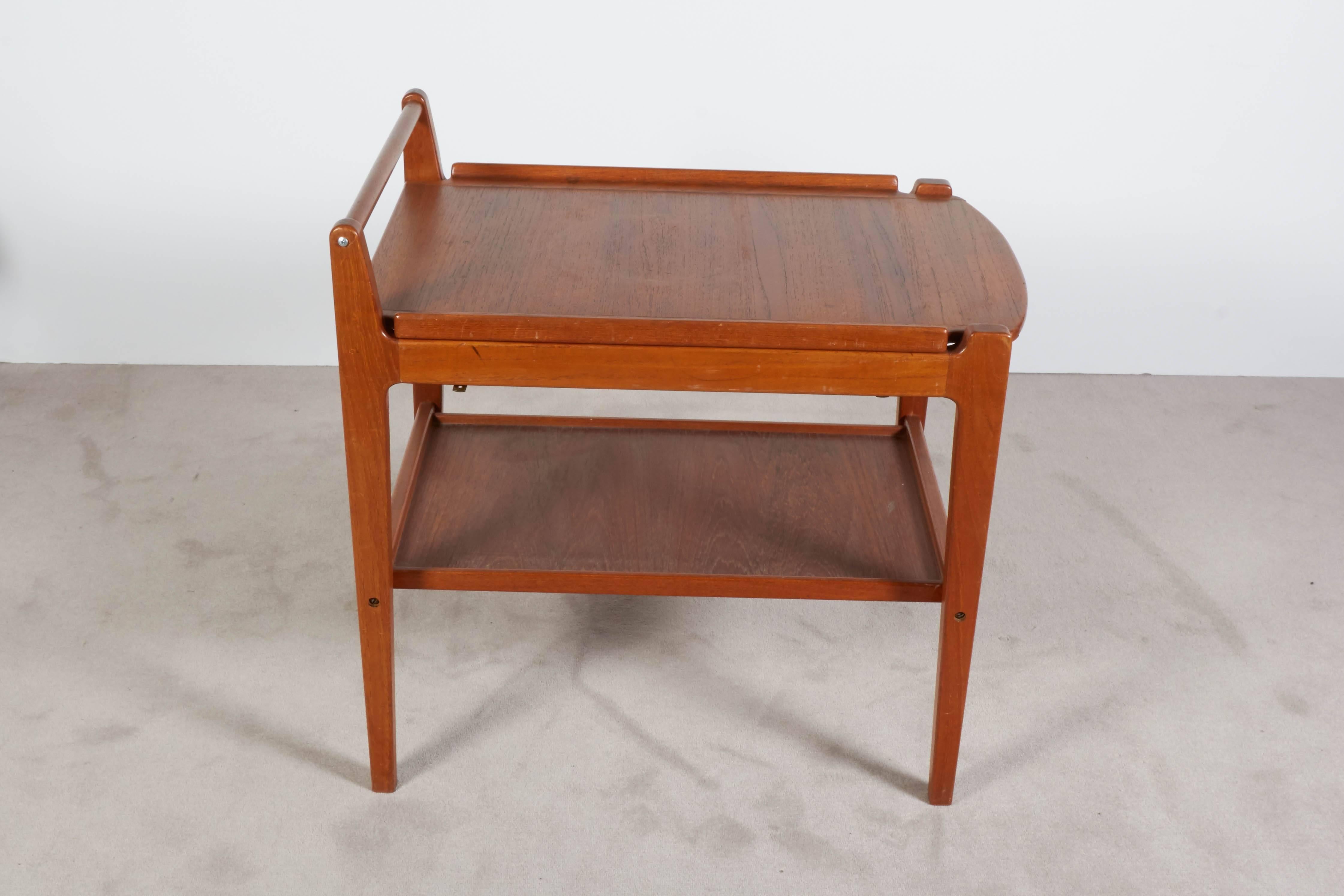 Danish Scandinavian Modern bar cart, produced circa 1960s, crafted entirely of teak, with removable tray top and secondary shelf. Very good vintage condition, recently refinished, including loss of caster wheels.