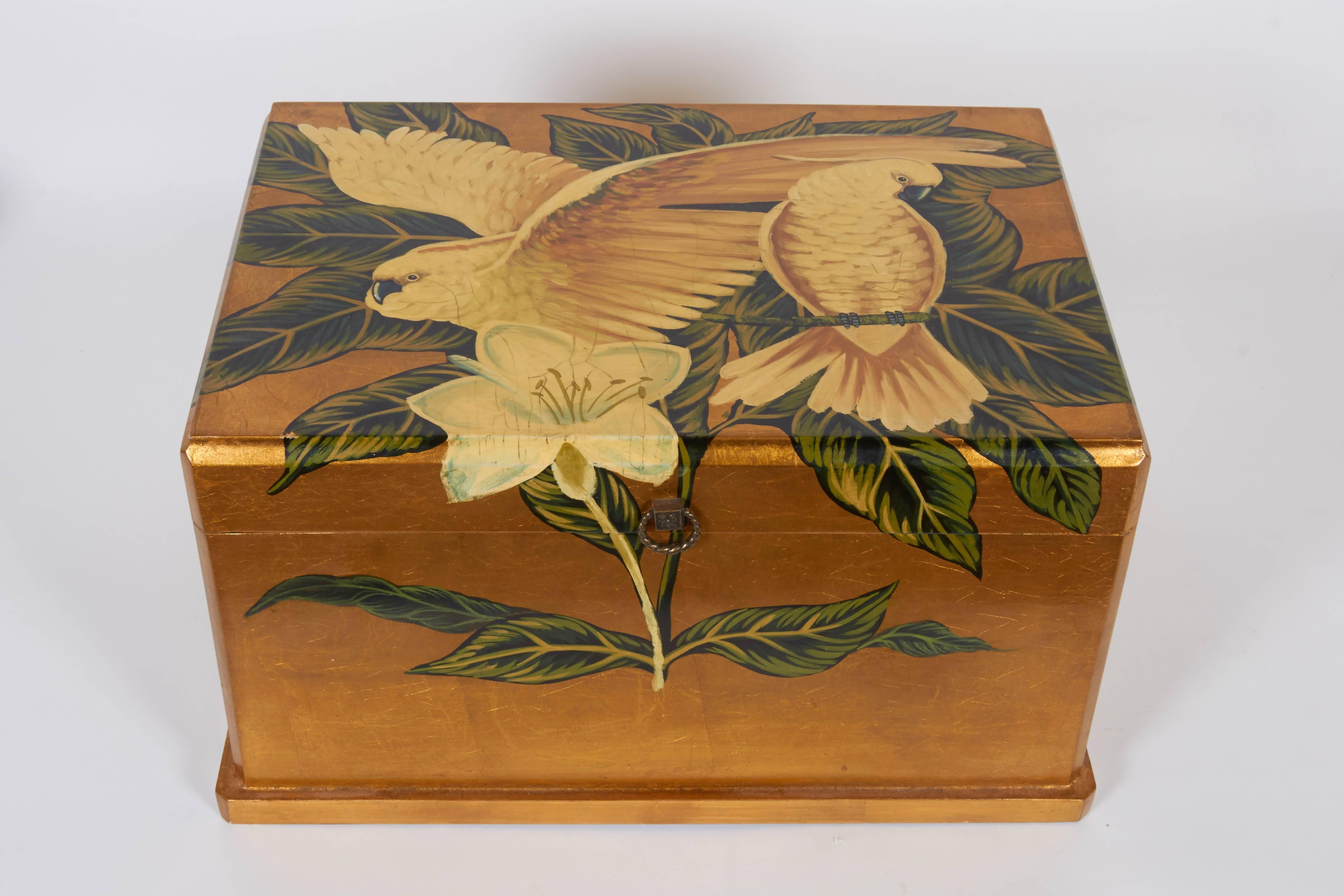 A Mid-Century era lacquered gold leaf jewelry box with hinged top, hand-painted decoration with cockatoos among foliage. Very good vintage condition, wear consistent with age and use.

11078
