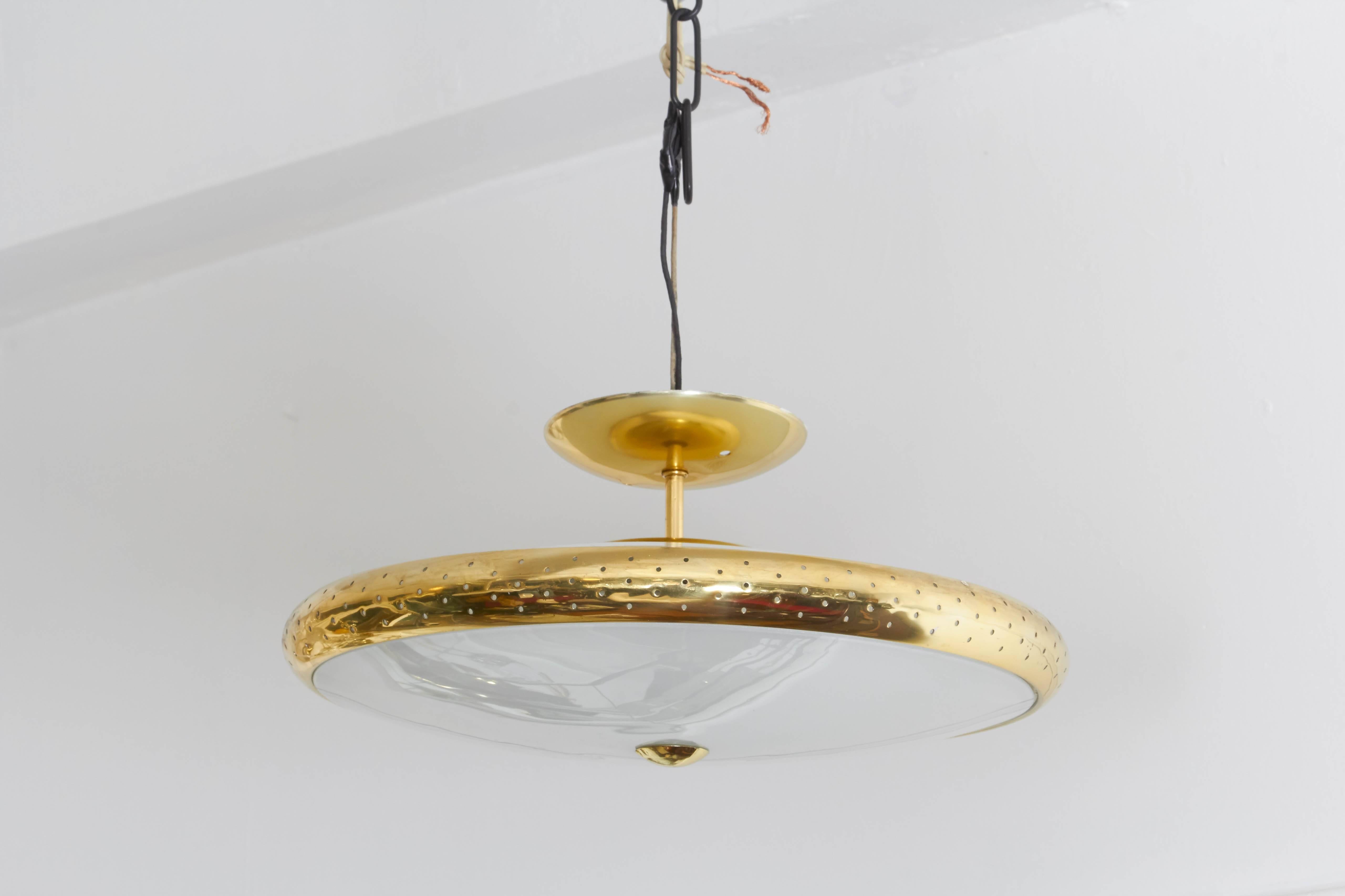 Mid-Century Modern 1960s atomic pendant light, of saucer form with frosted glass shade against brass perforated frame, suspended from stem with dome canopy. Very good vintage condition, minimal wear consistent with age and use.

NE101.