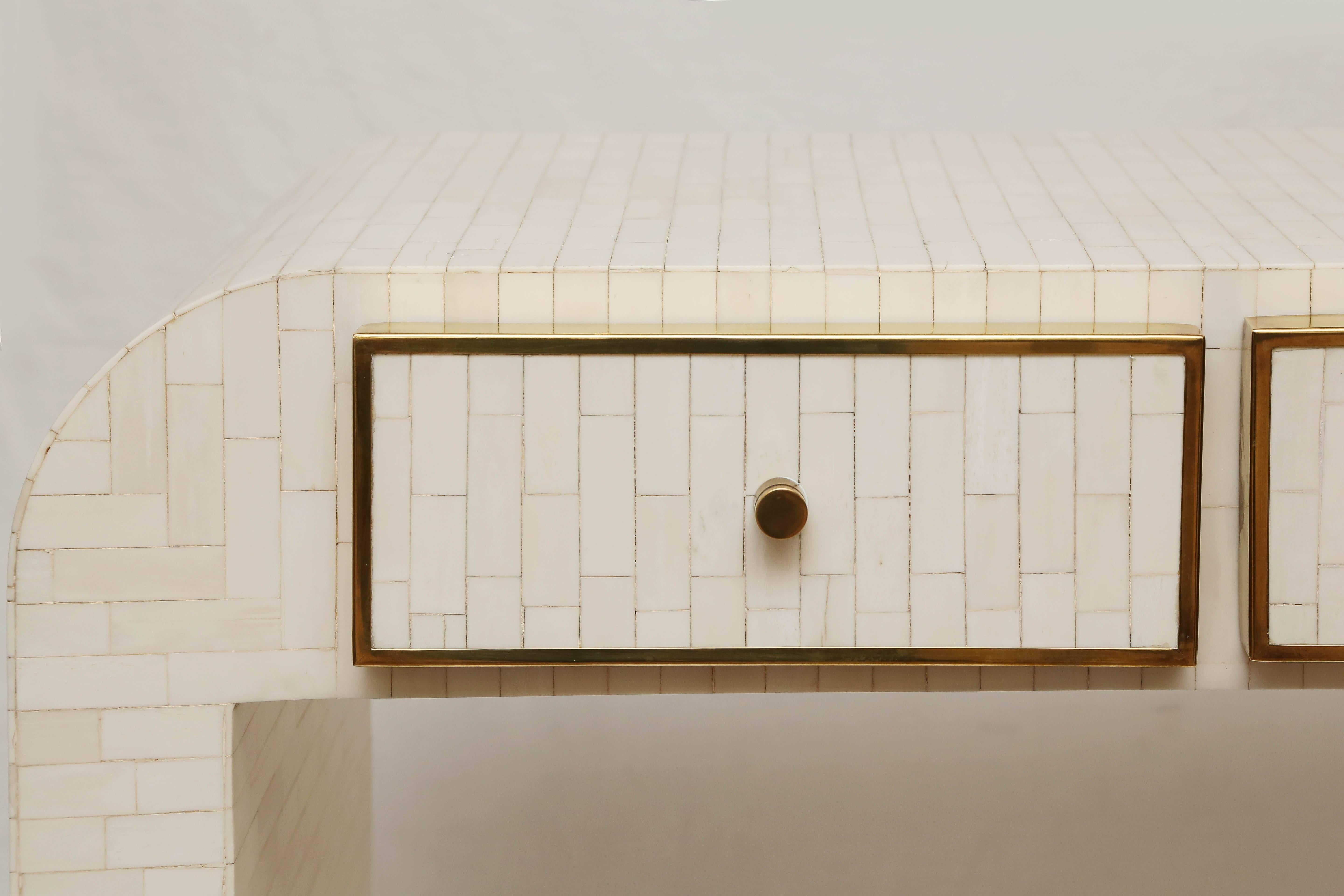 Rectangular bone tile console with brass details around the drawers as well as brass pulls.
The unique and simple design creates a great look.