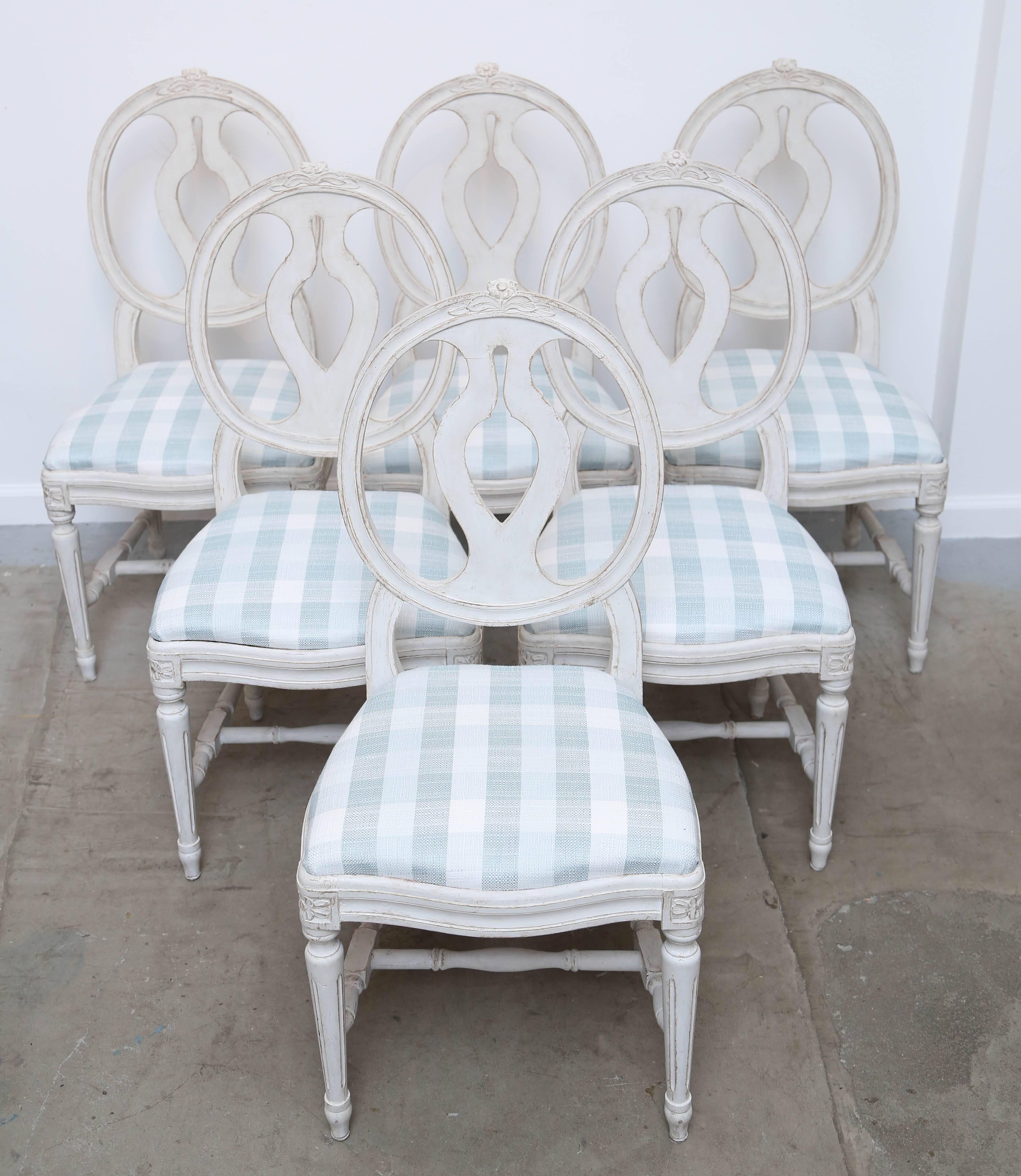 Set of six antique Swedish Gustavian Style painted dining chairs 
Late 19th century Classic medallion back with urn shape detail and carved
floral detail on top rail. Rosettes top of tapered fluted legs, bottom stretcher.
Painted in Swedish white