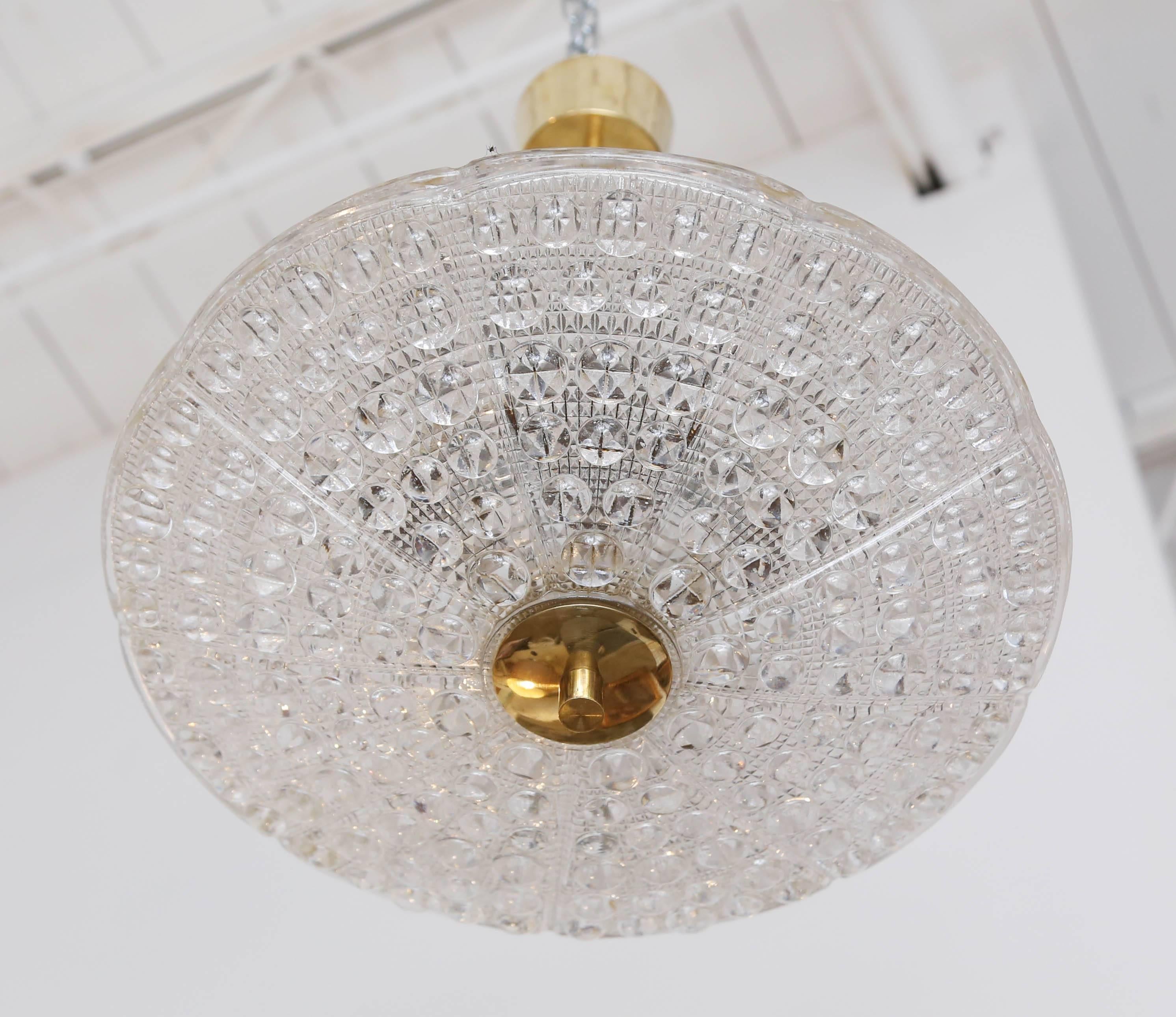 Carl Fagerlund for Orrefors bubble crystal duel disc chandelier, circa 1960s.
Classic Orrefors round carved textured and bubble round glass shades with
brass stem, canopy and bottom finial. Fixture has been cleaned and rewired
to US standard,