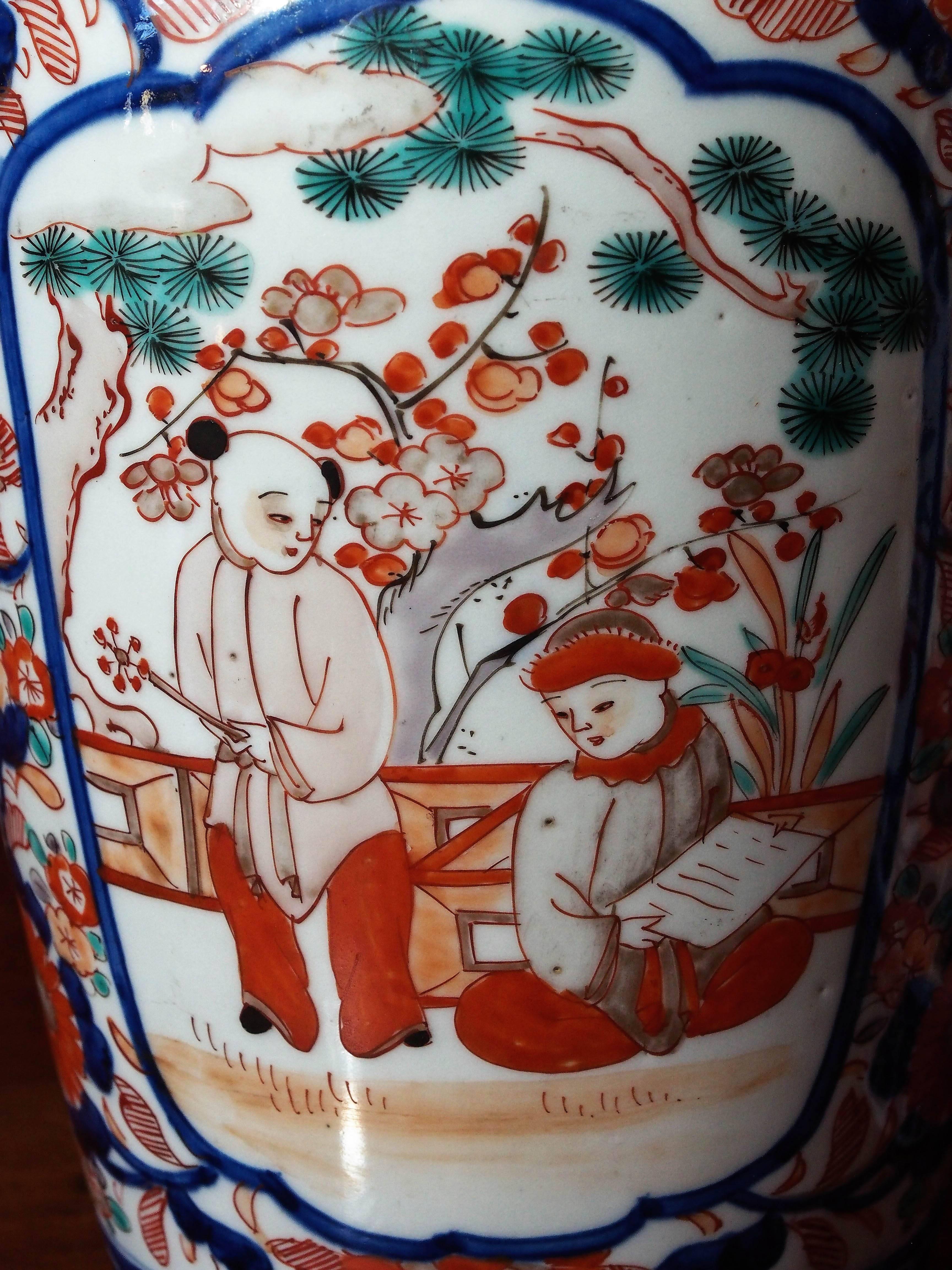 Pair of Imari ribbed jars with floral decoration and central scenes of two boys in a garden.
