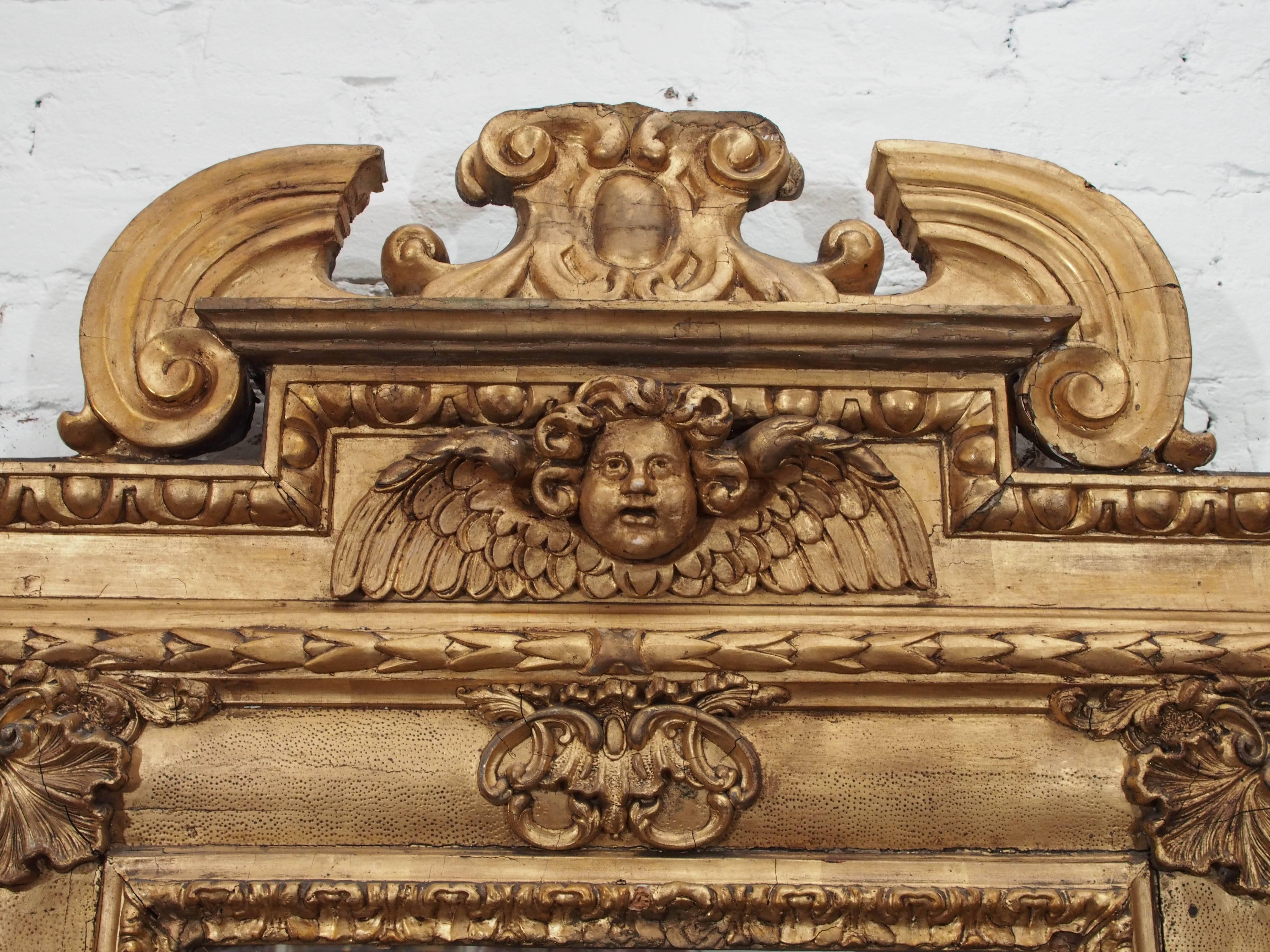 Italian giltwood mirror with foliate decoration and cherub head.