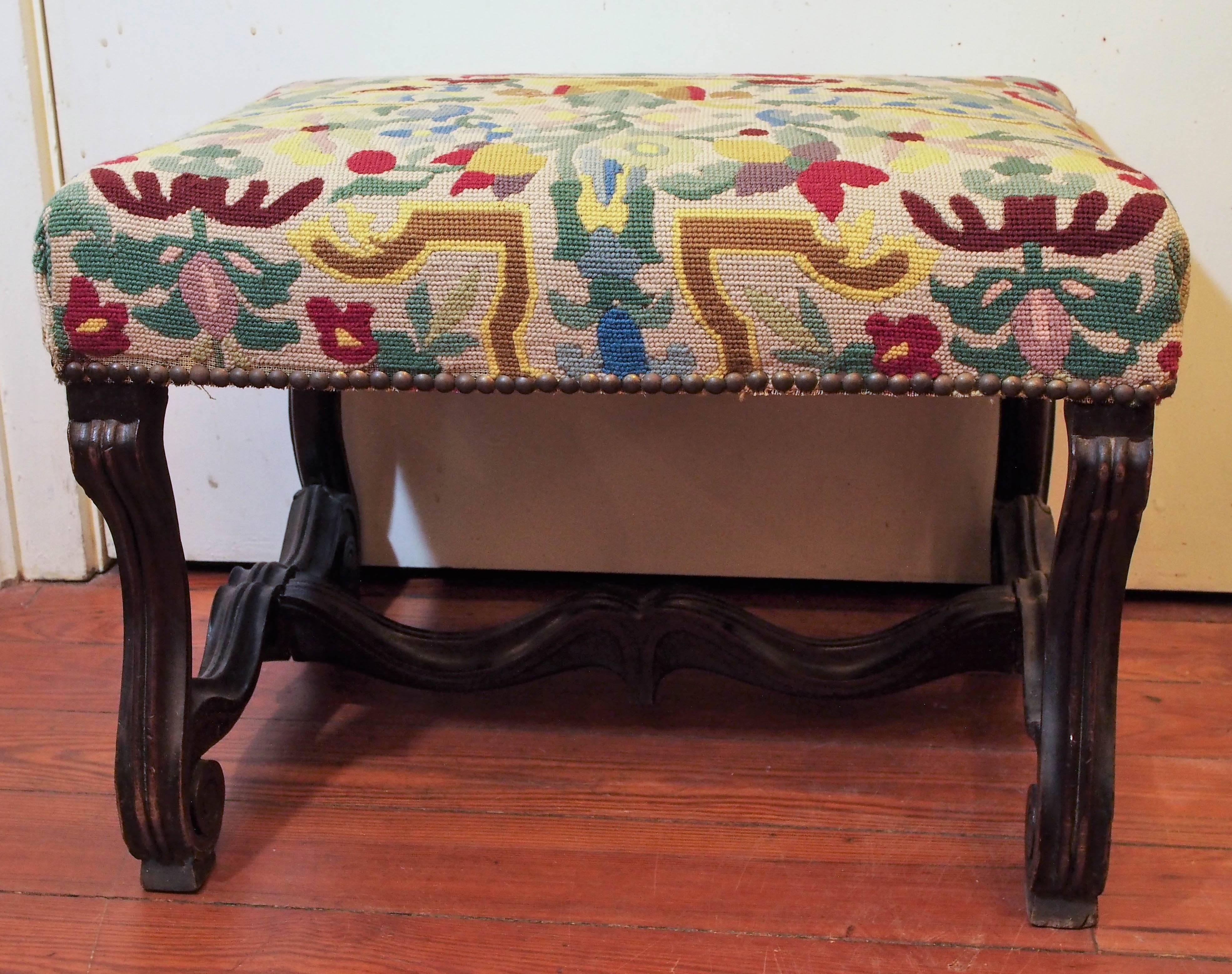 French 19th walnut Os De Mouton (lambs bone) stool with needlepoint covering one of an associated pair.