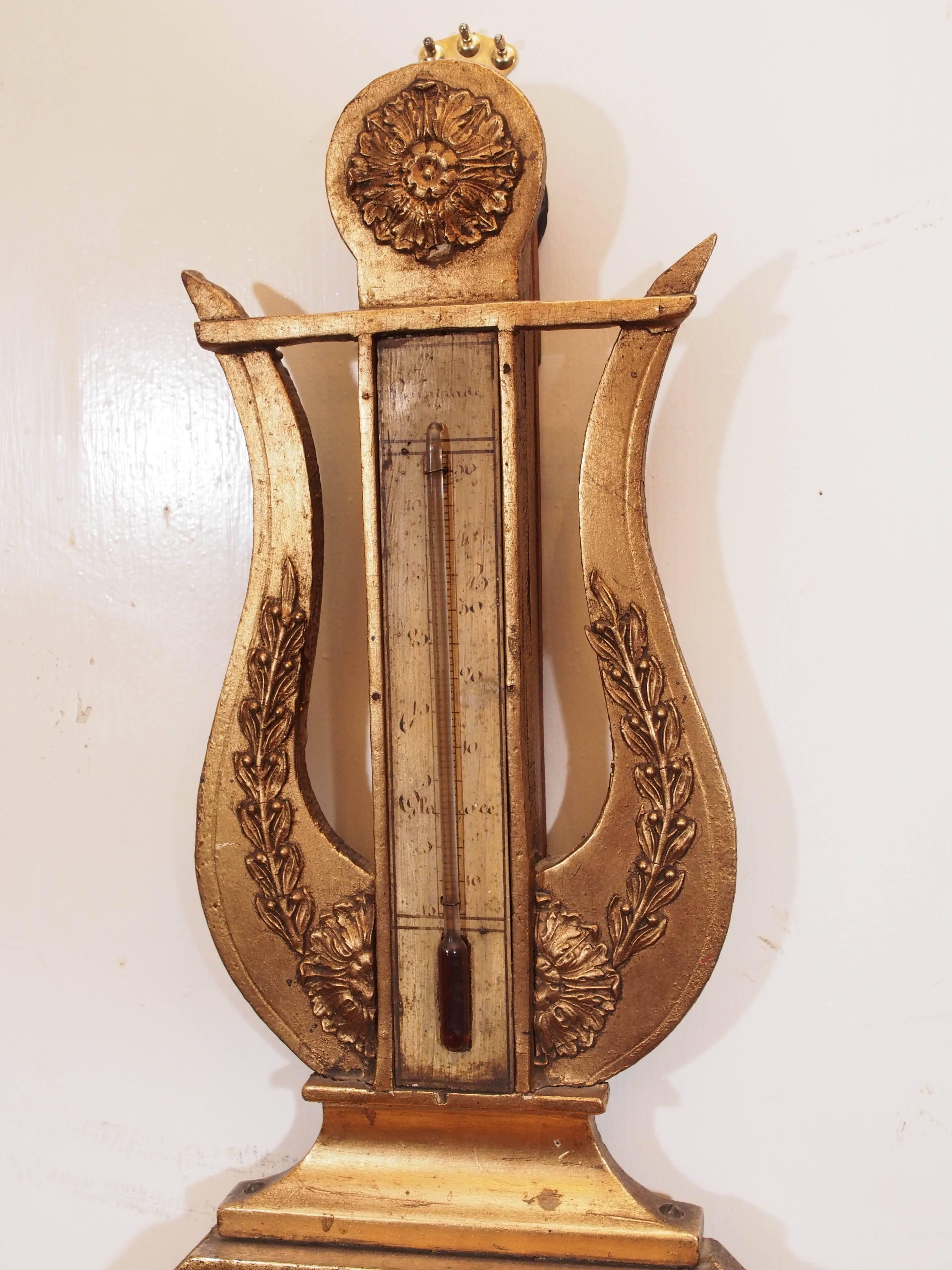 French Empire giltwood barometer or thermometer with lyre form over a octagonal shape. 19th Century.