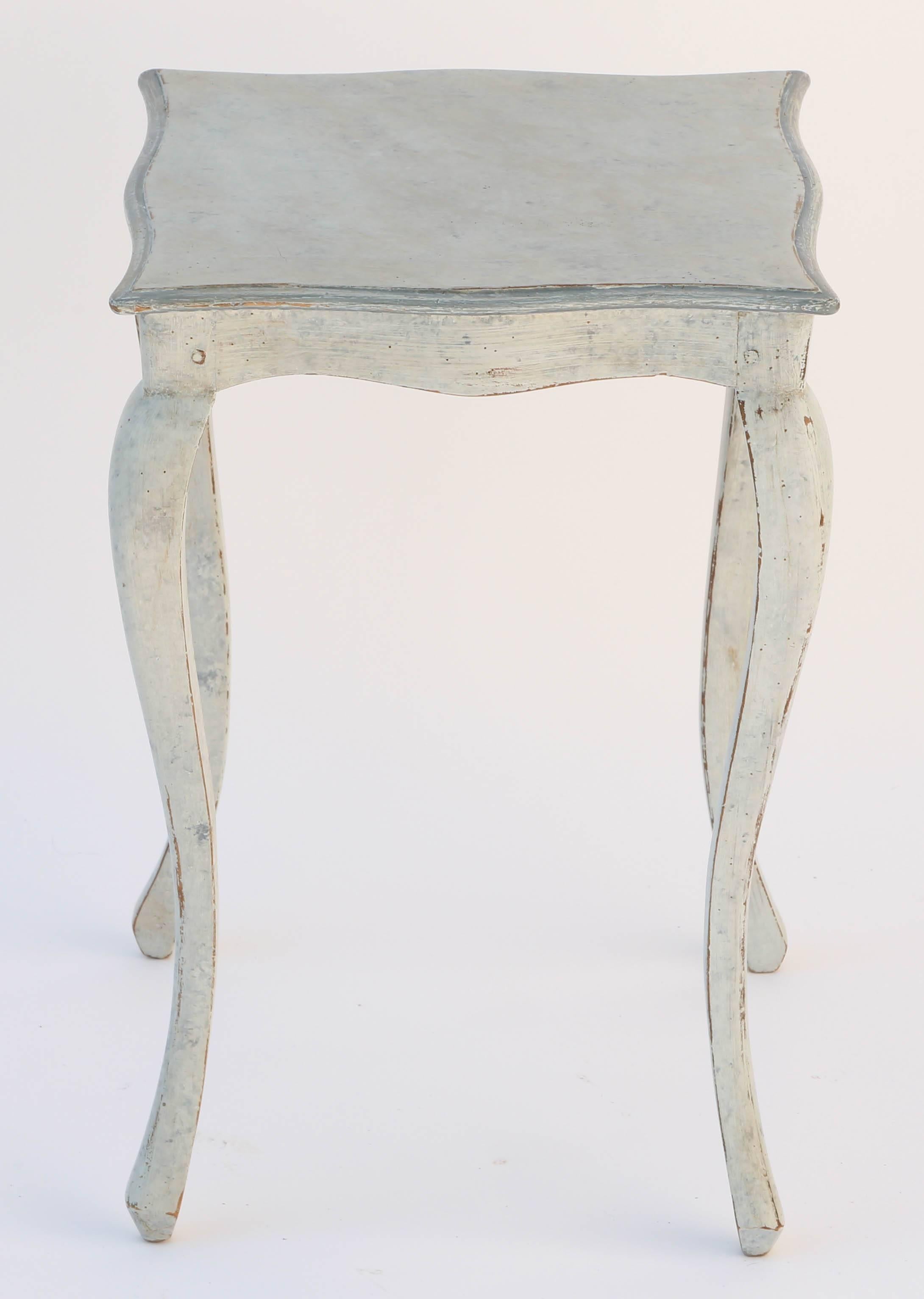 Small side table, having a distressed, painted finish, its molded square top with serpentine edge, on conforming base, raised on cabriole legs.

Stock ID: D8429