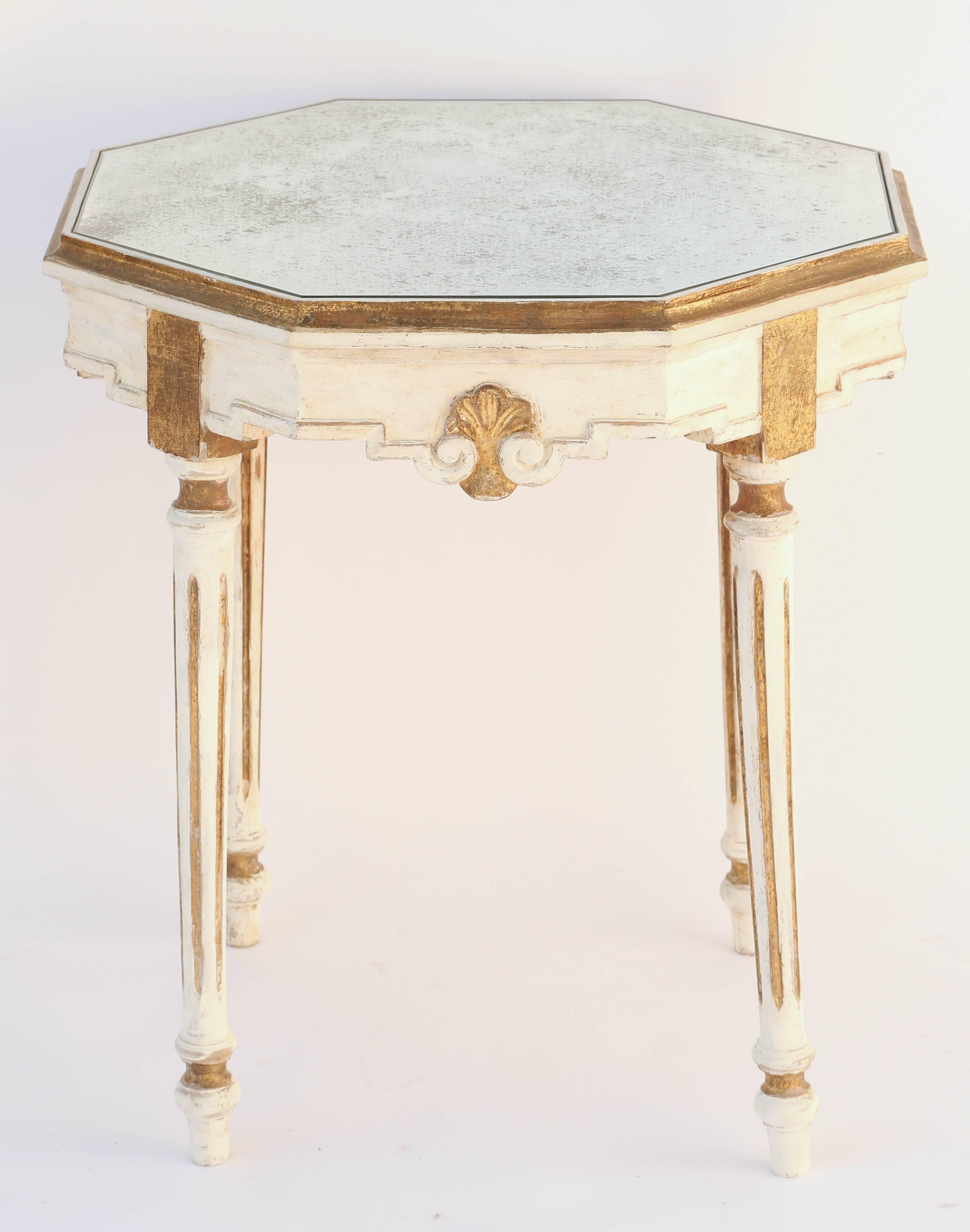 Side table having an octagonal top of distressed mirror, in molded frame, on fielded apron, trimmed in stepped border centered with a palmette, raised on round, tapering, fluted legs, ending in touipe feet.

Stock ID: D9429