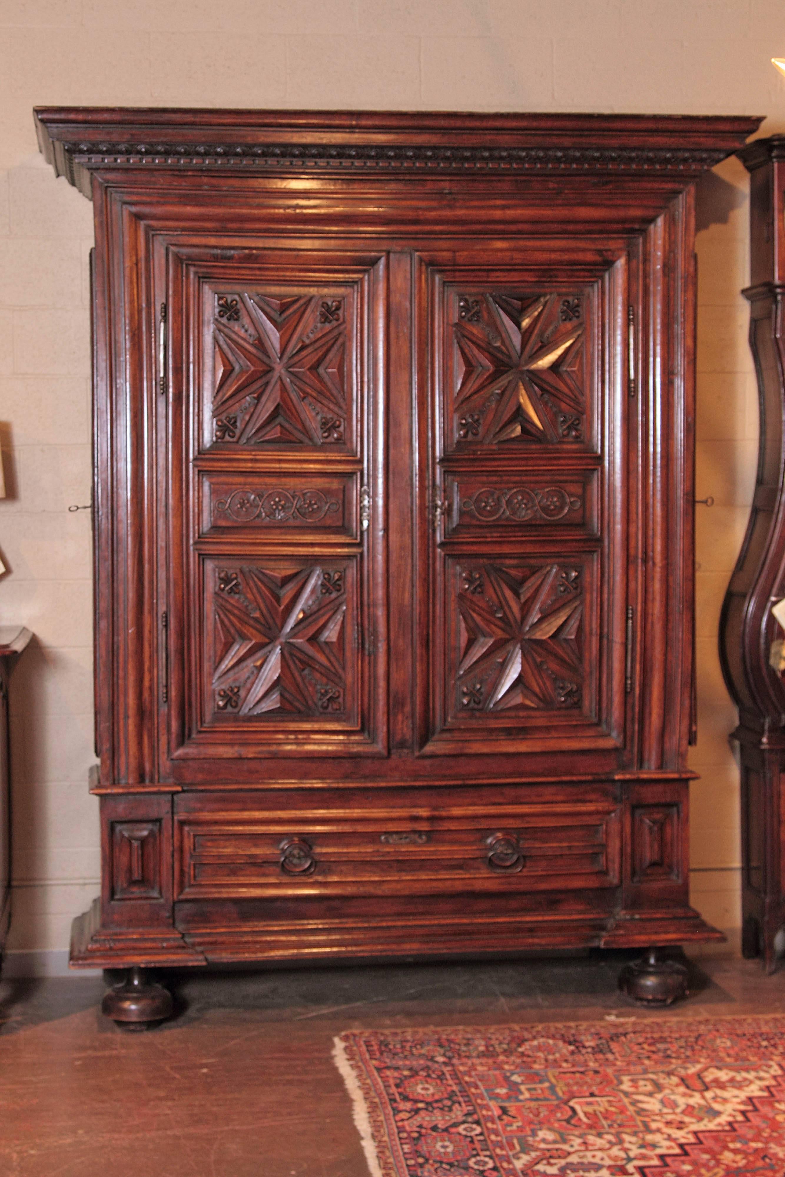 This exceptional armoire from the Perigord region and from the time of King Louis XIII of France region is a beautiful yet very functional piece that offers extra storage. Created, circa 1670, the antique, fruitwood wardrobe sits on front bun feet