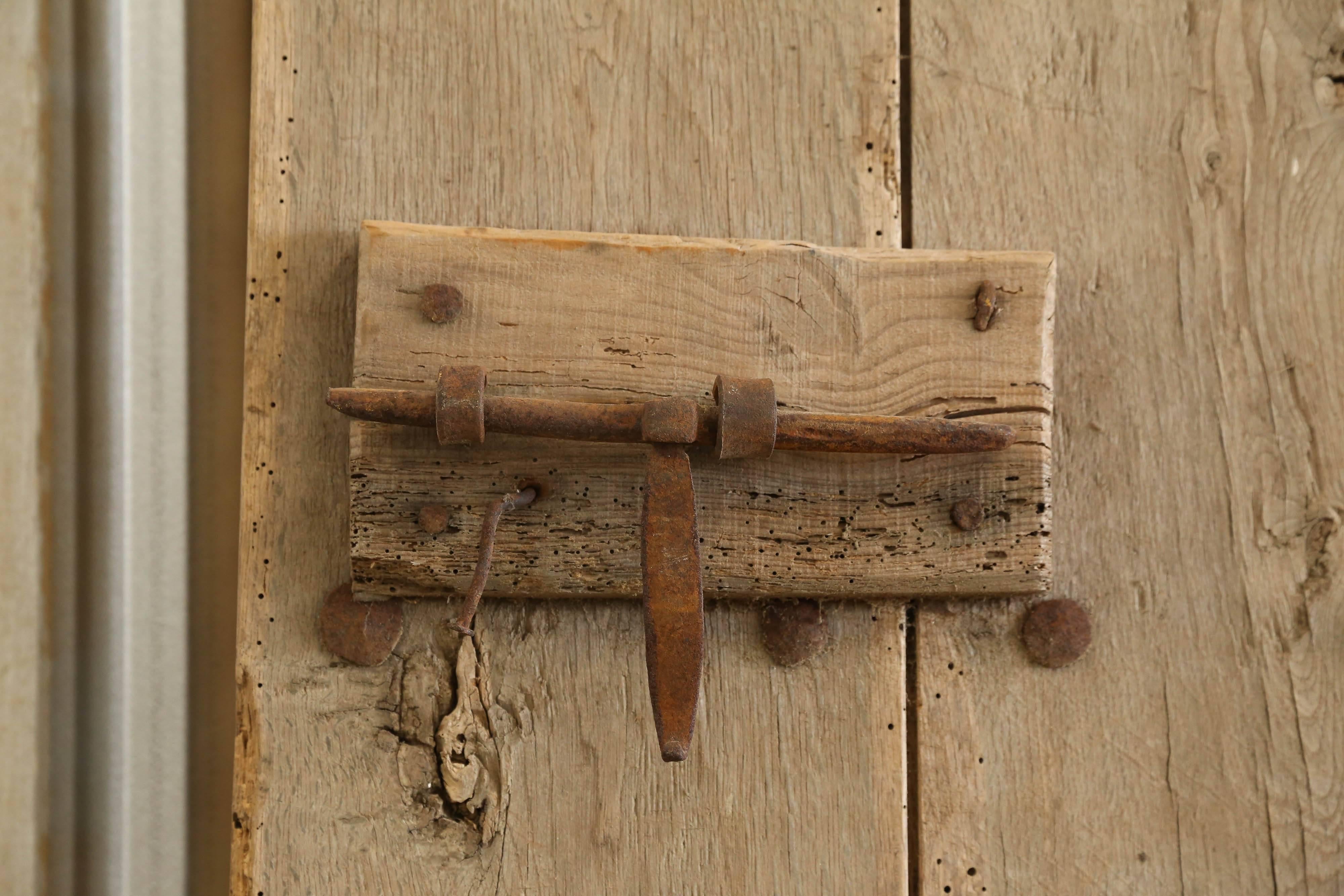 This is a single, rustic, chestnut door from Spain with iron handmade nails and original hardware. Great for wine room or to turn into coffee tabletop.