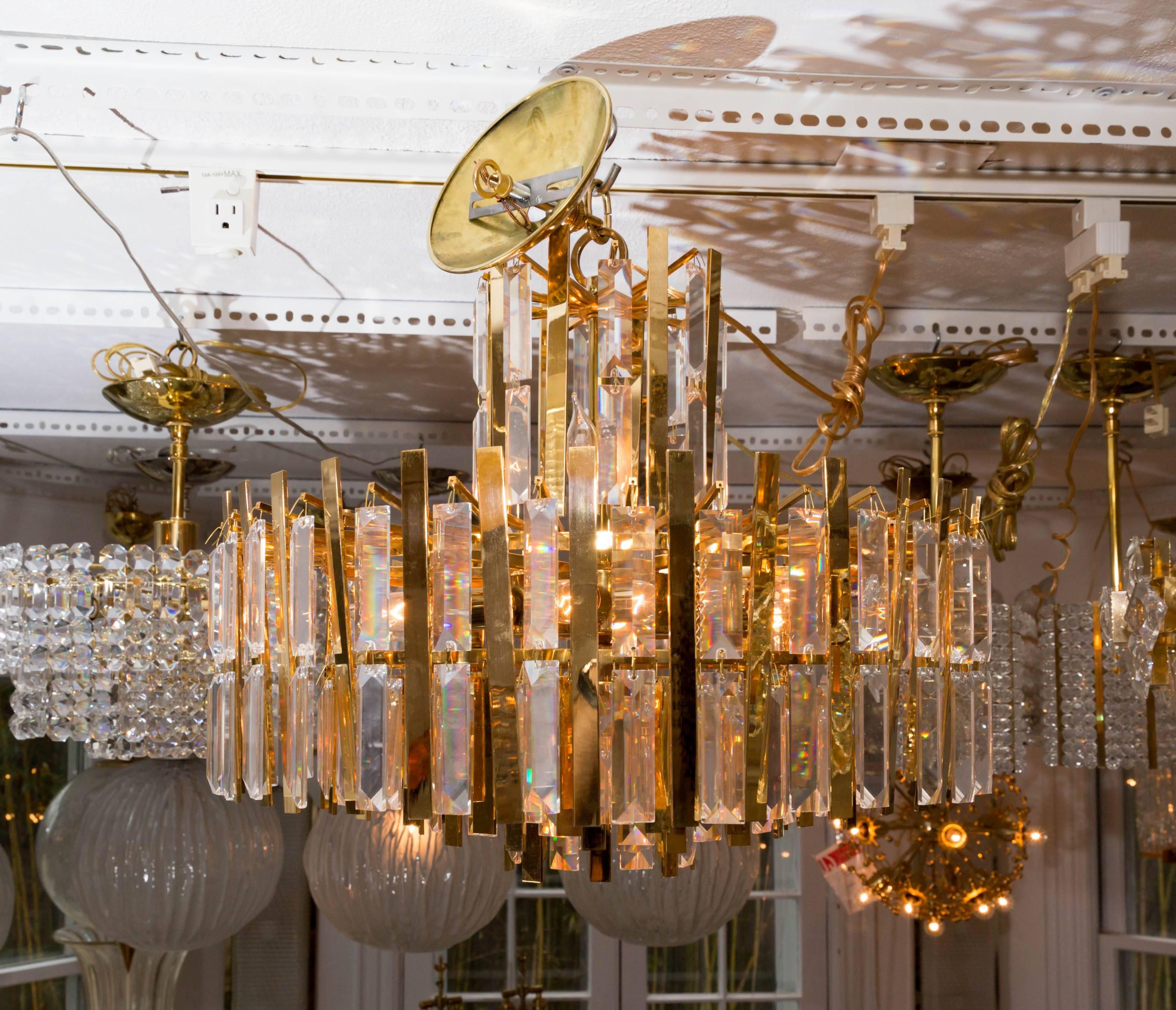Mid-Century Modern Brass Chandelier Composed of Multiple Suspended Brass Strips and Crystal Prisms For Sale