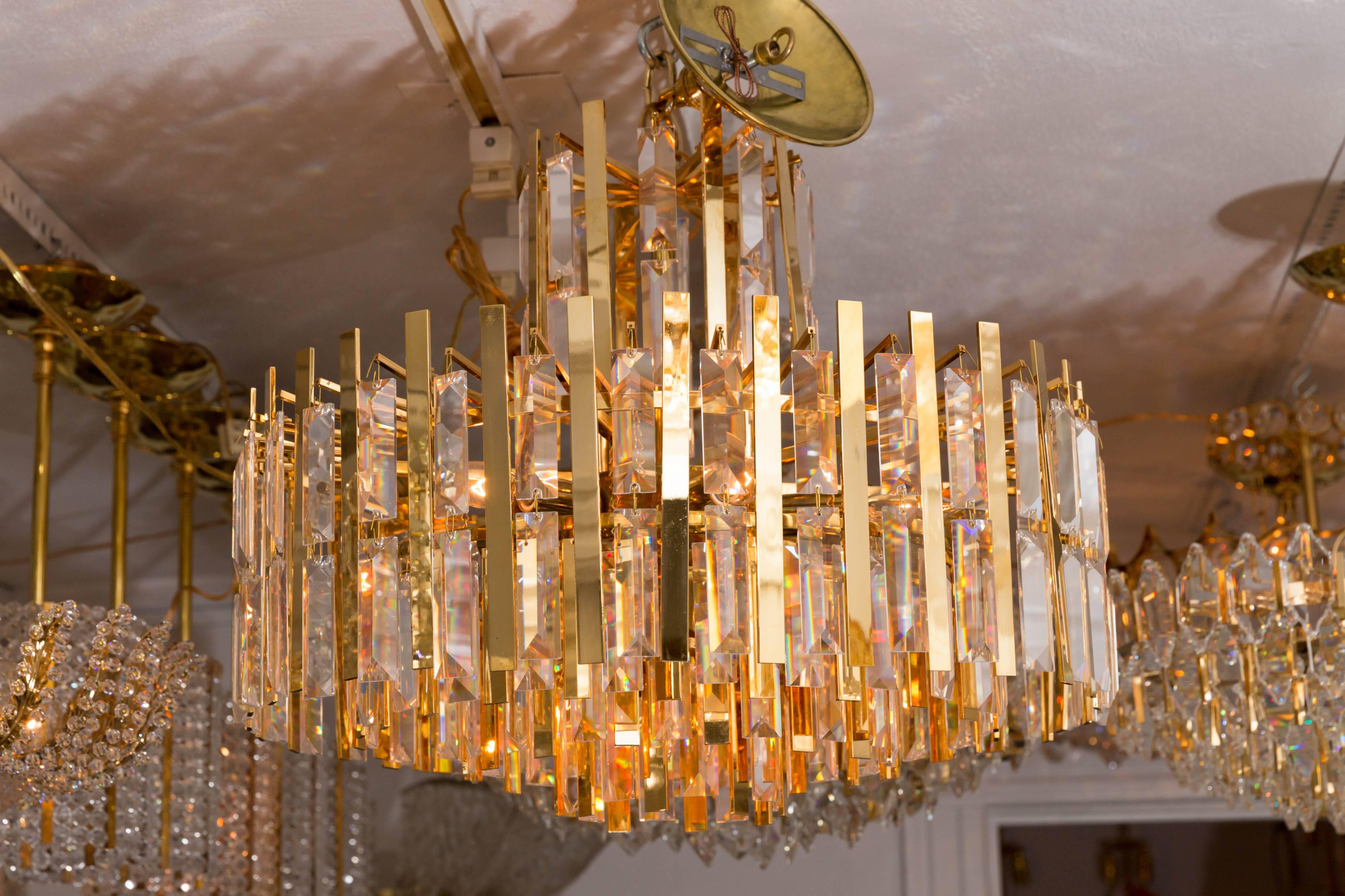 Austrian Brass Chandelier Composed of Multiple Suspended Brass Strips and Crystal Prisms For Sale