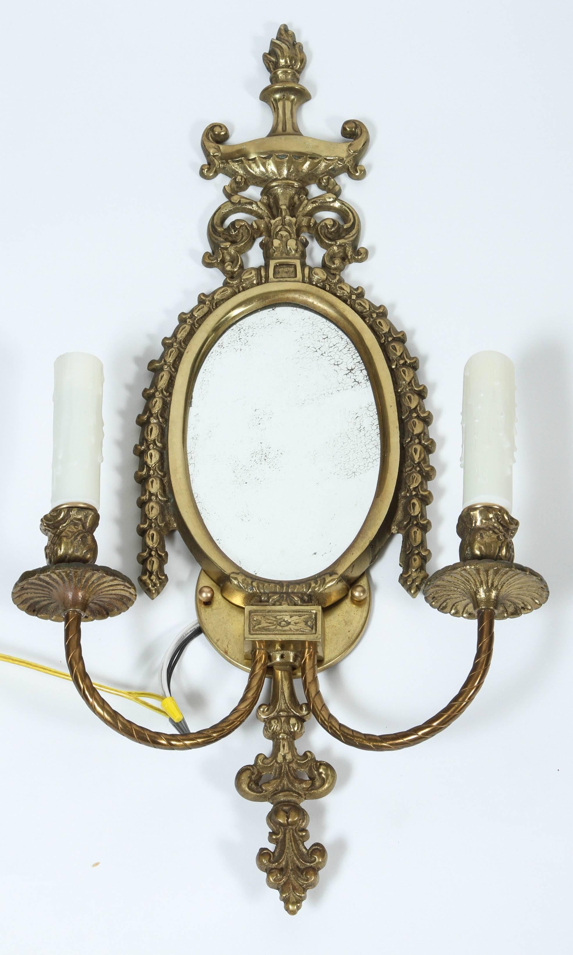 Pair of newly wired vintage brass two-arm sconces with faux candlesticks and original beveled mirror backs.