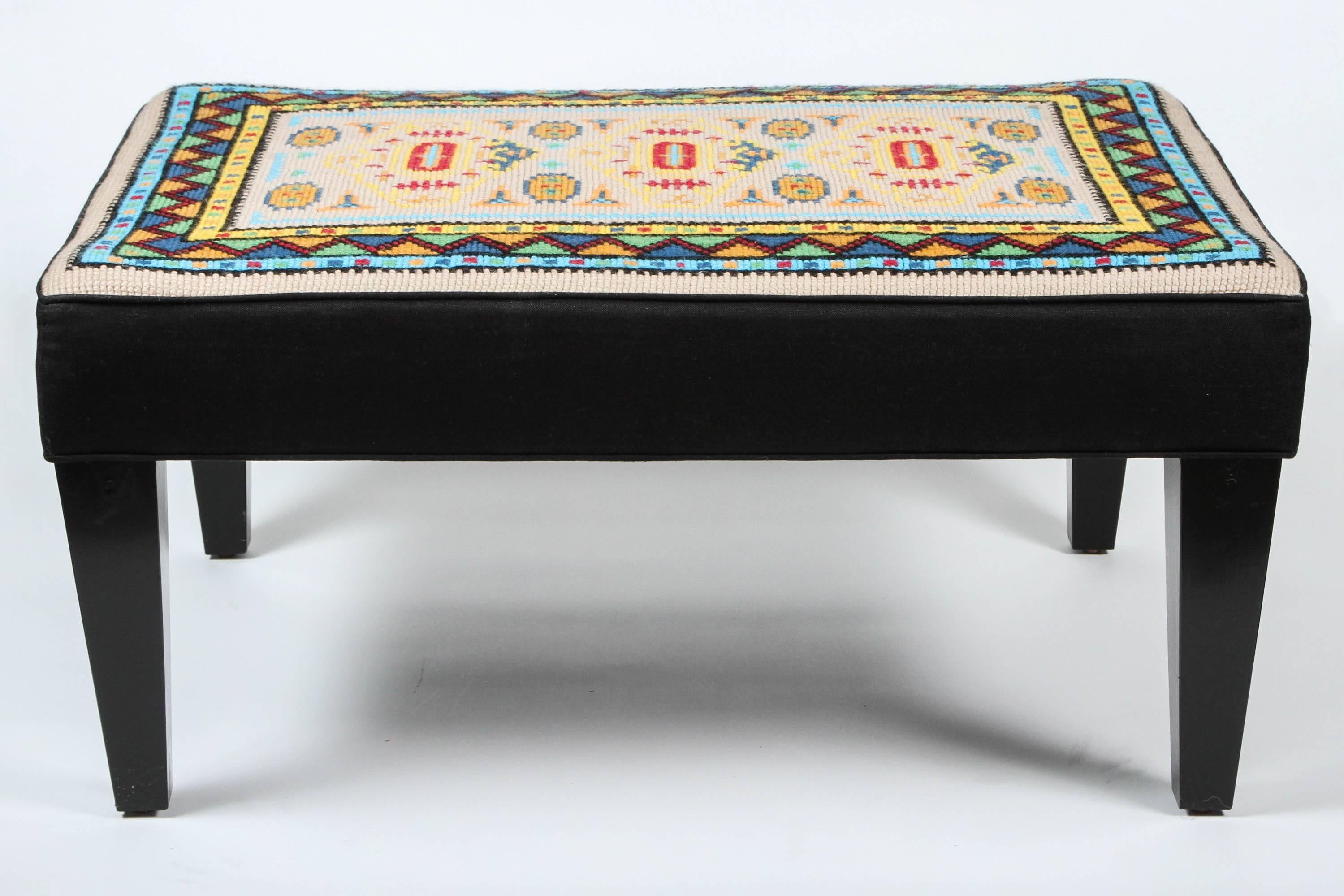 Vintage wool needlepoint panel newly made into an ottoman with linen sides and wood legs.