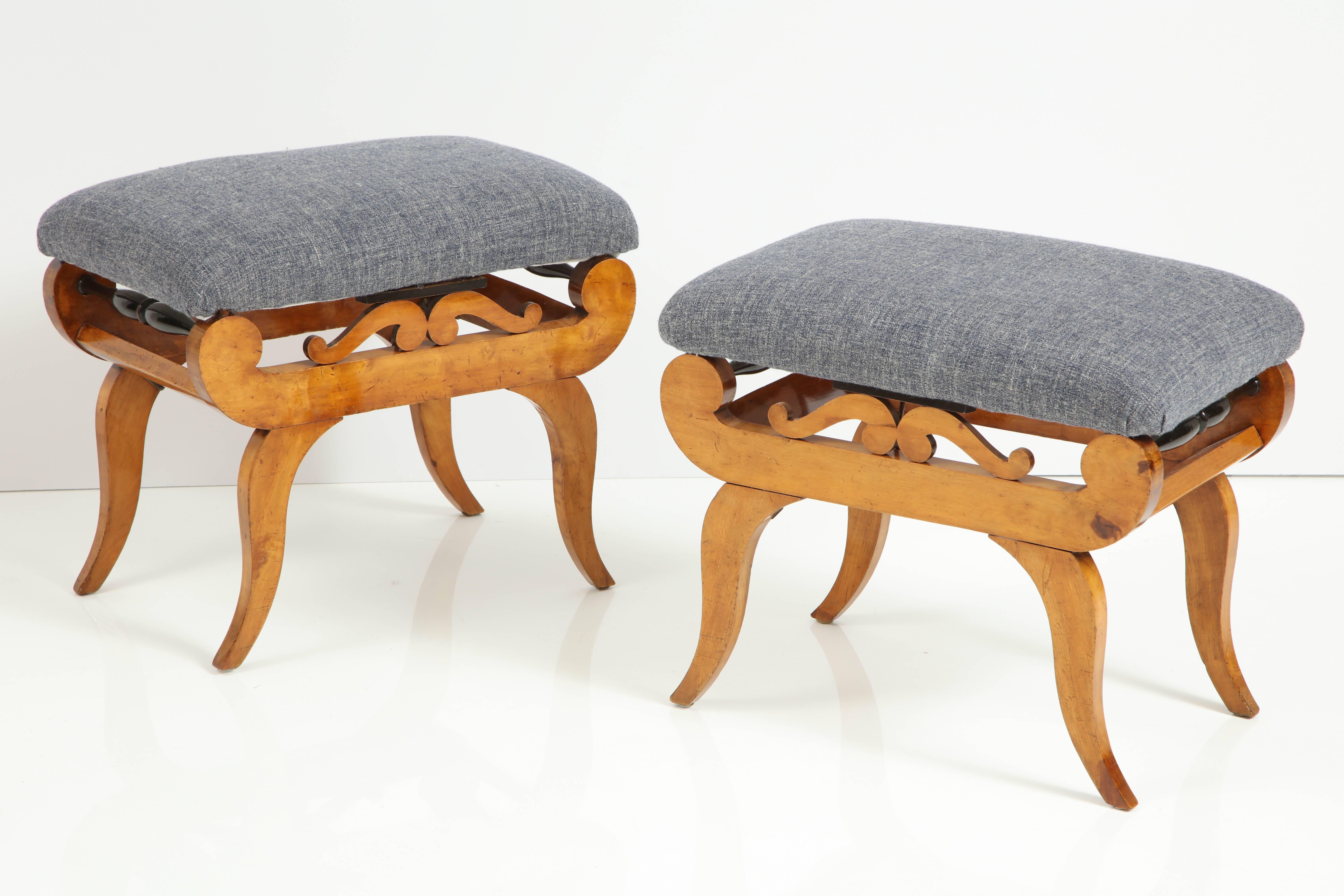 A pair of Swedish Karl Johan birchwood and ebonized stools, circa 1830s, each with a rectangular upholstered seat raised on a carved scrolled supports and ending with gentle curved legs.

Re polished. Good color. Recovered.