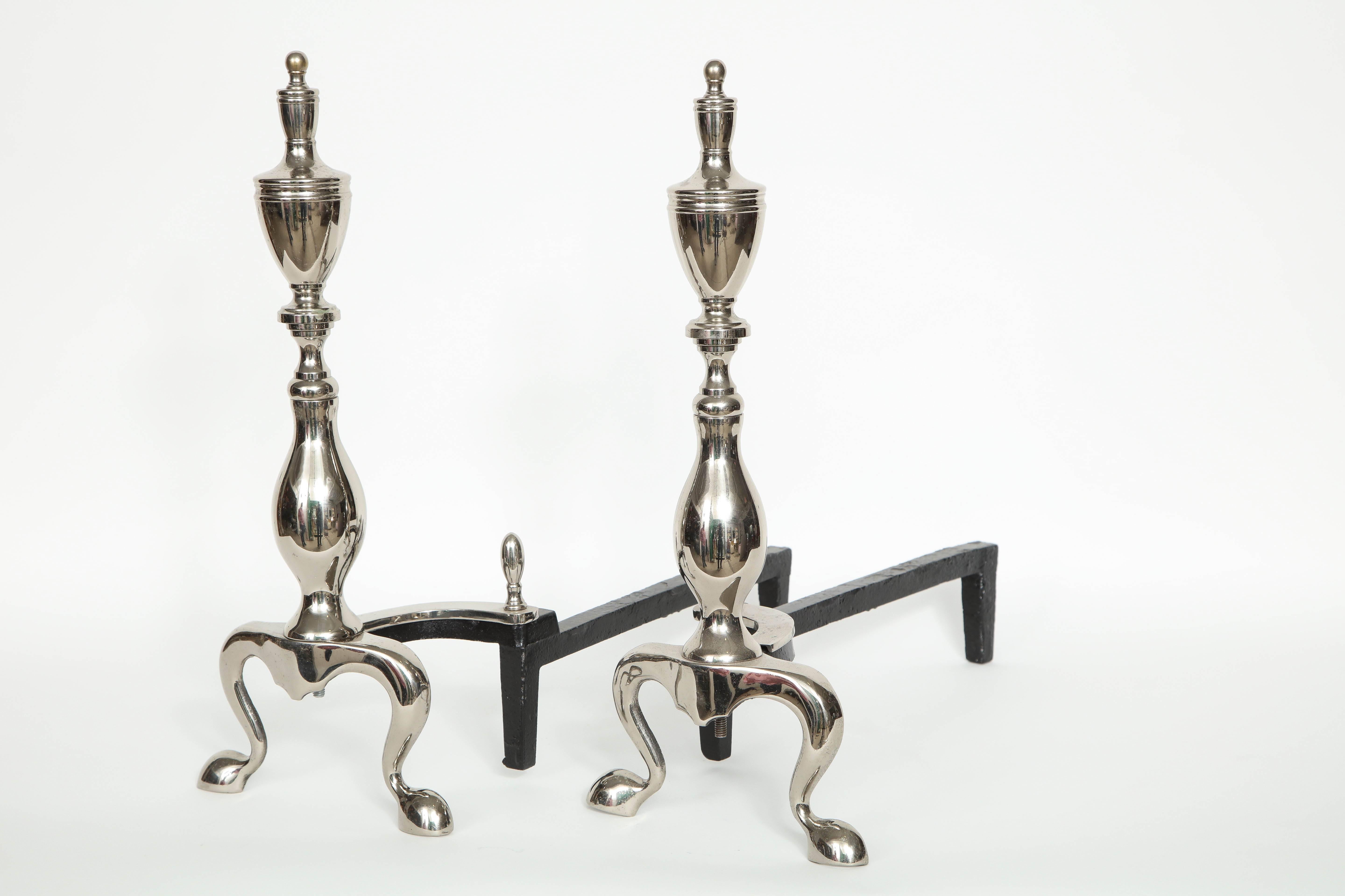 Pair of Mid-Century polished nickel andirons with a Chippendale influence and graceful Silhouette.