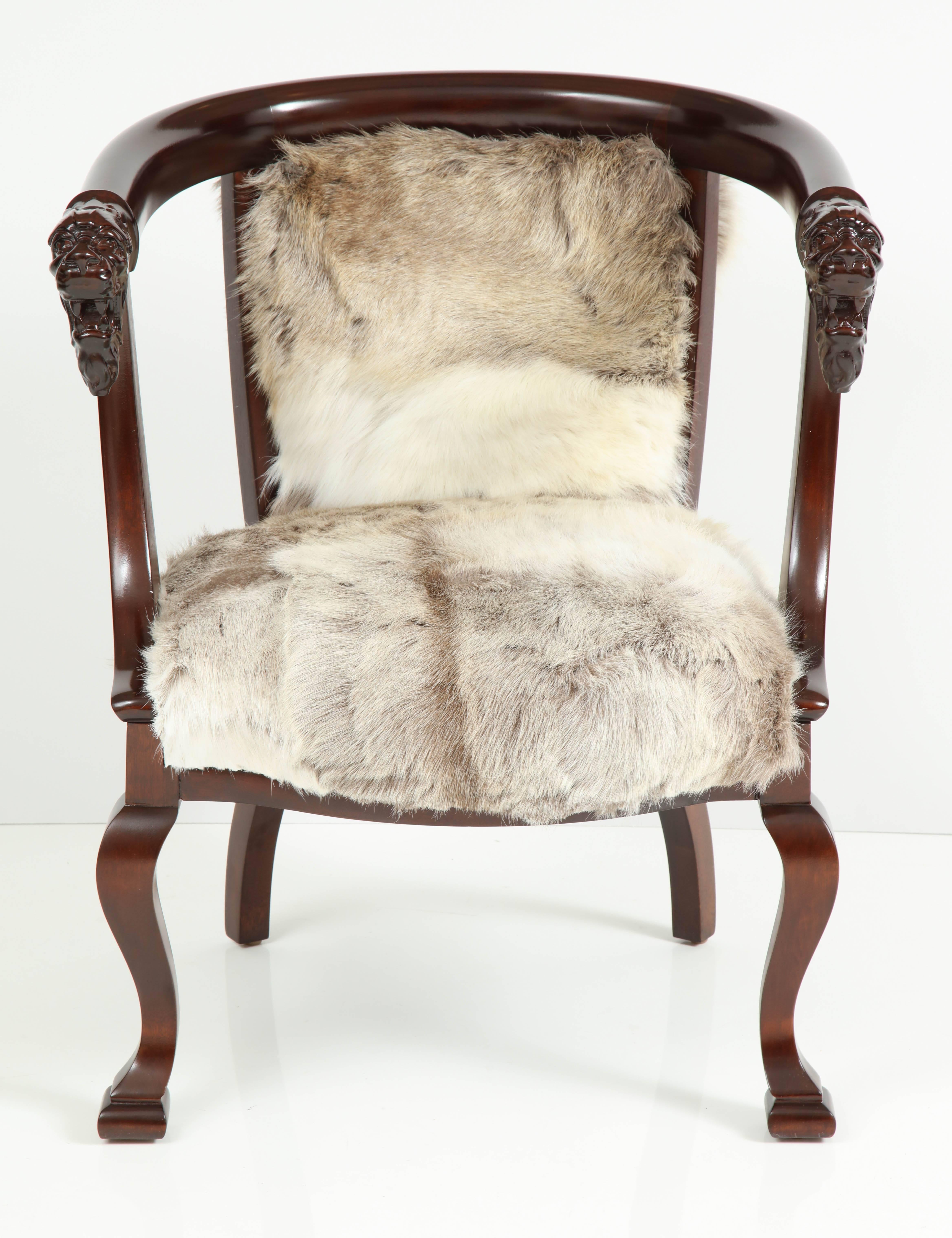 Exquisite Mahogany framed barrel back club chair featuring hand-carved lion head detail on each arm with sinuous graceful legs. Chair has been mint restored in a rich brown finish and upholstered in Finnish reindeer hides. A great statement piece