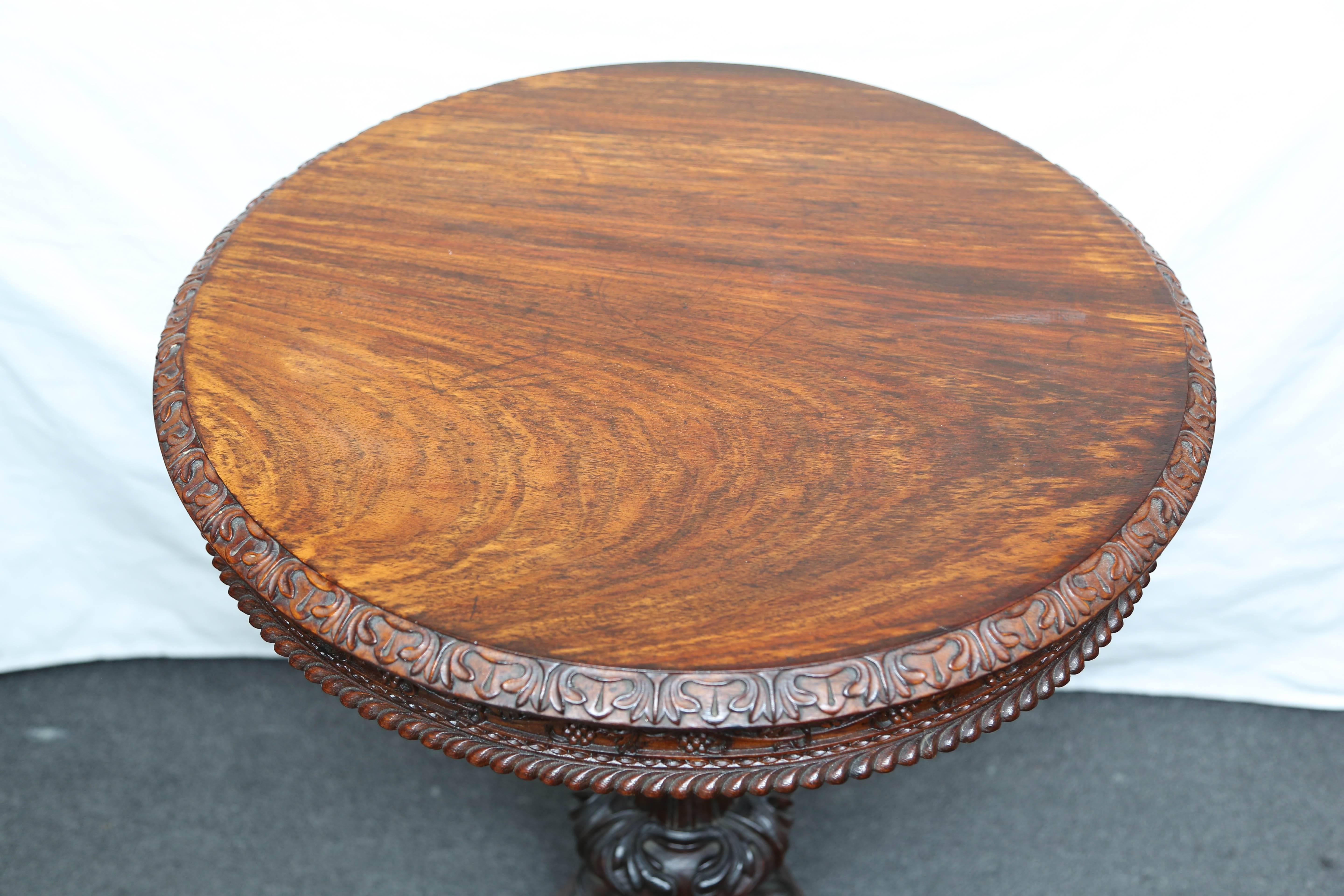 Rare and stunning rosewood table, original patination and color. Elaborate carving with vine and foliage apron. An exquisite example.