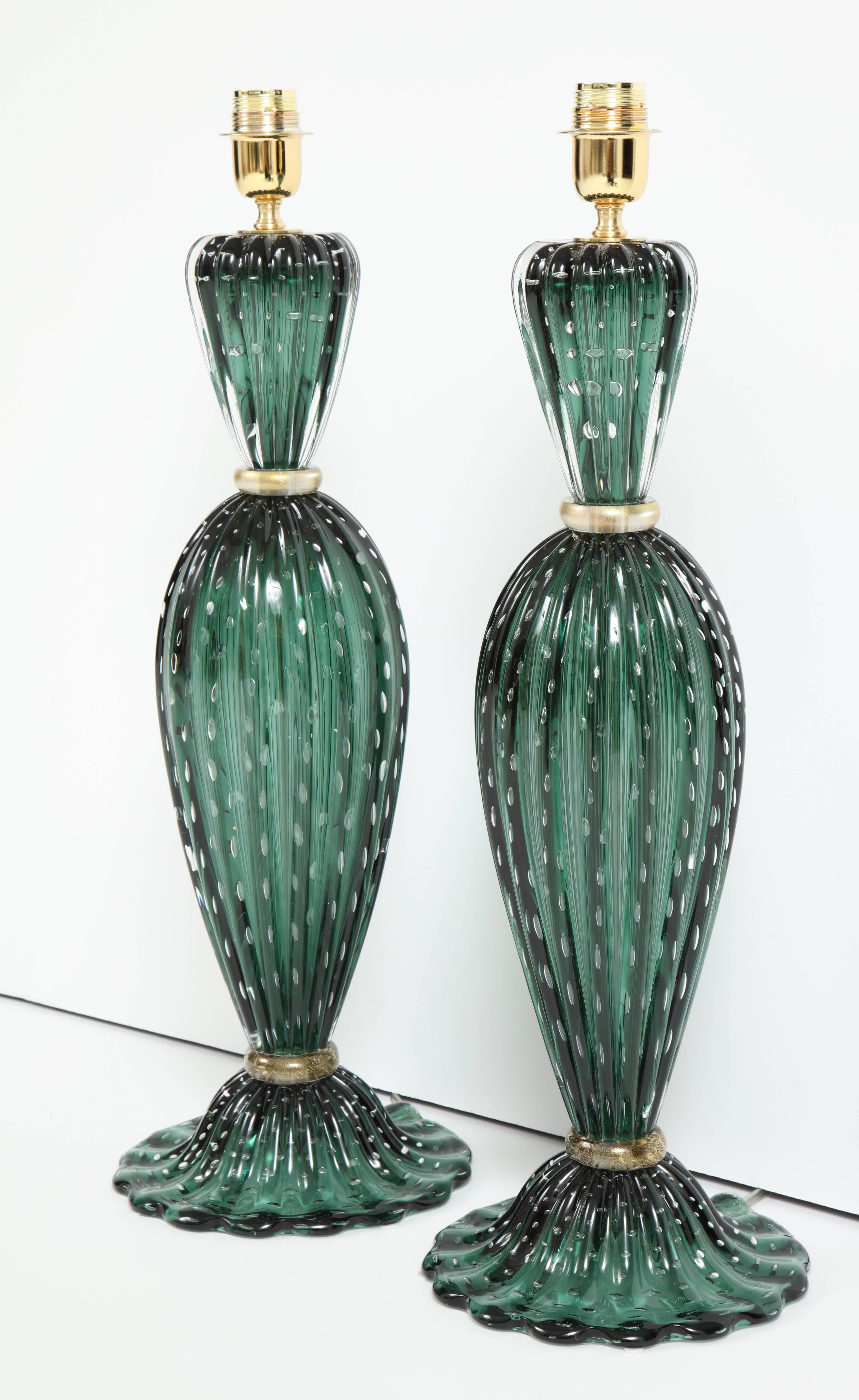 The color of this pair of green Italian handblown Murano glass lamps is so unique and absolutely gorgeous! Emerald green Pulegoso glass lamps. Elegantly shaped with teardrop body and scalloped base. Gold rings separate each glass component. Wired