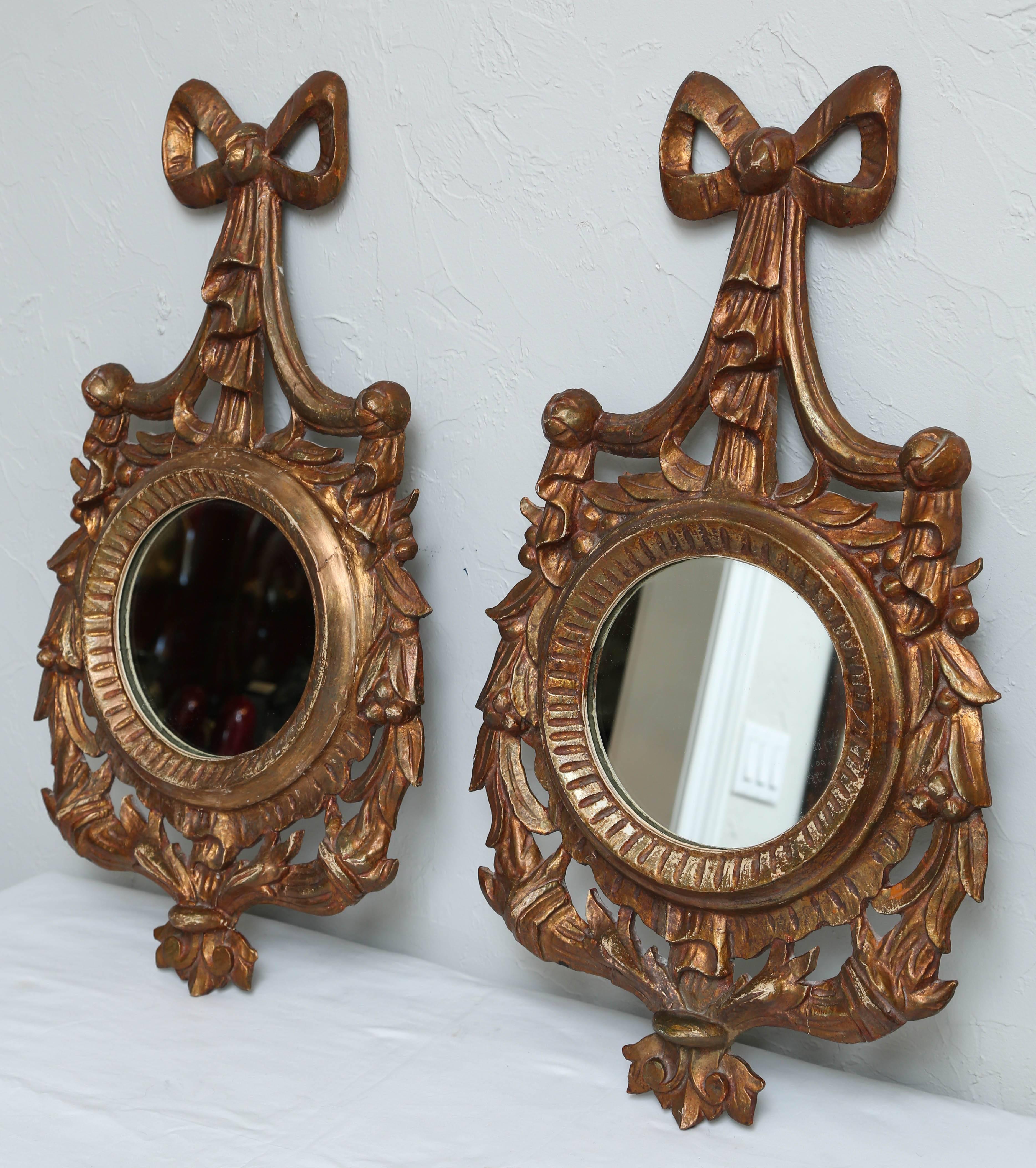 Pair of carved and gilded Italian round mirrors.