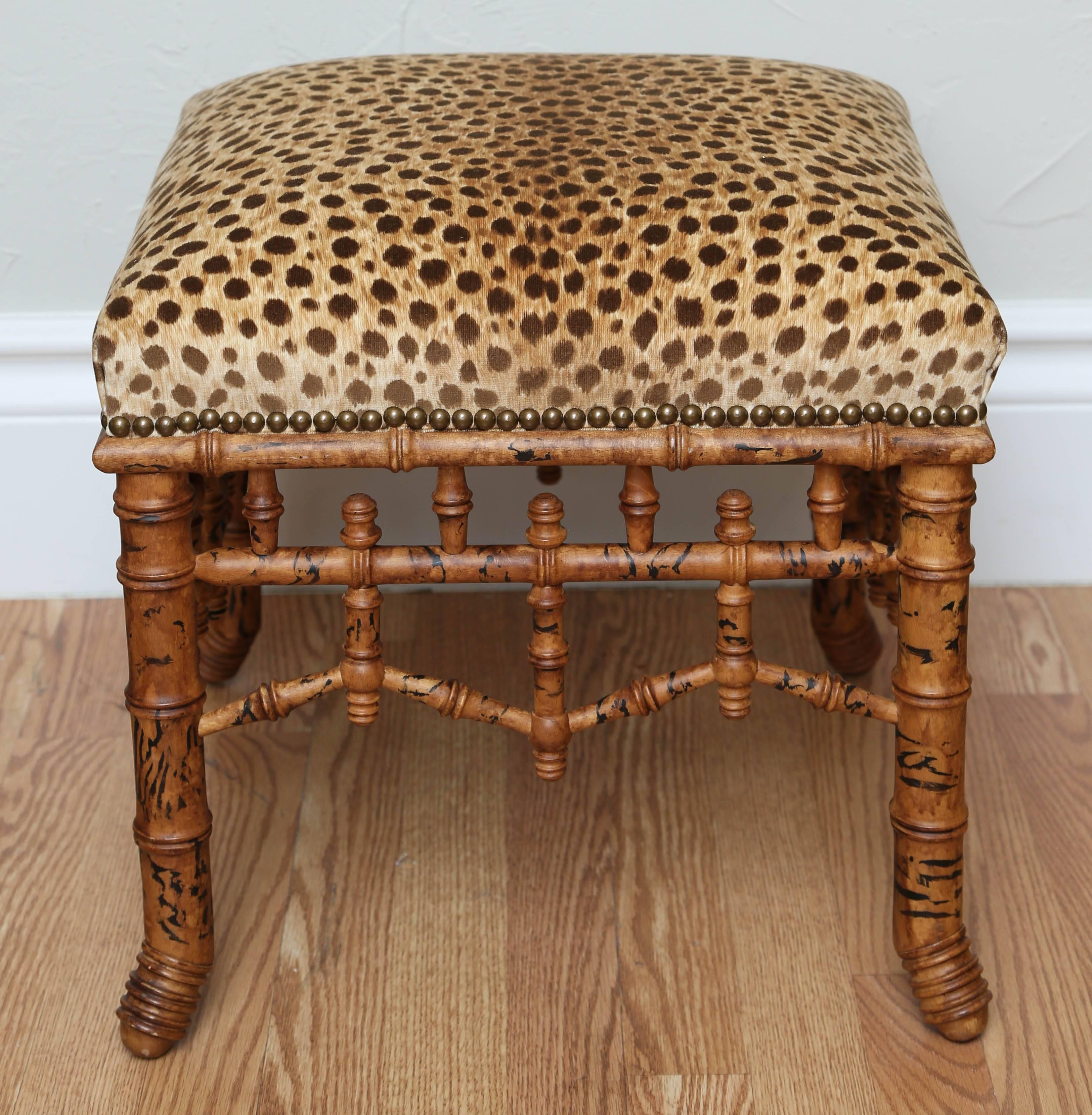 Charming faux bamboo wood bench with animal print velvet upholstery.