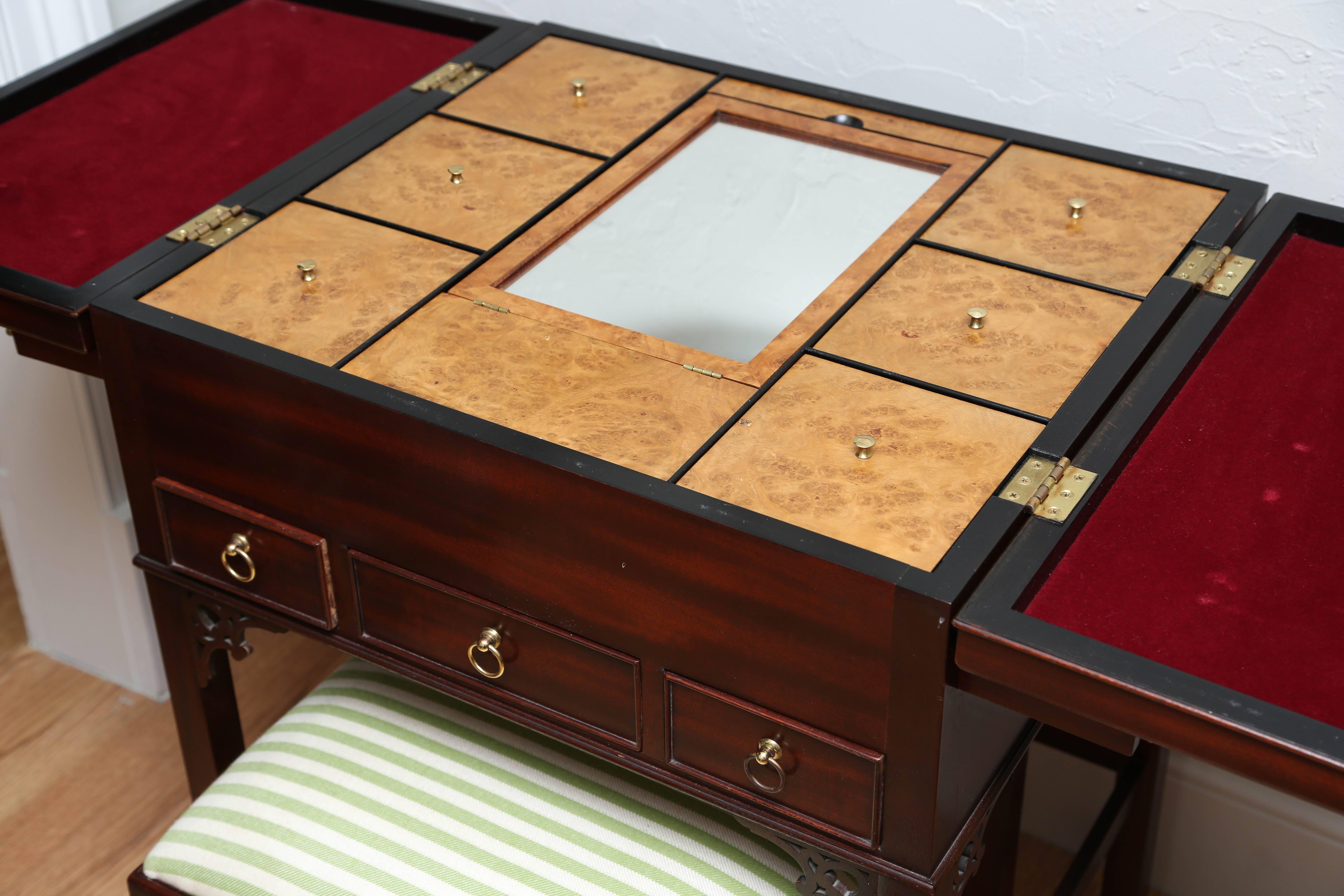Very unusual vanity/jewelry chest with built in storage compartments and hidden mirror by Baker Furniture Co. Accompanied by matching vanity stool.
This piece is 46.5 with both sides opened.