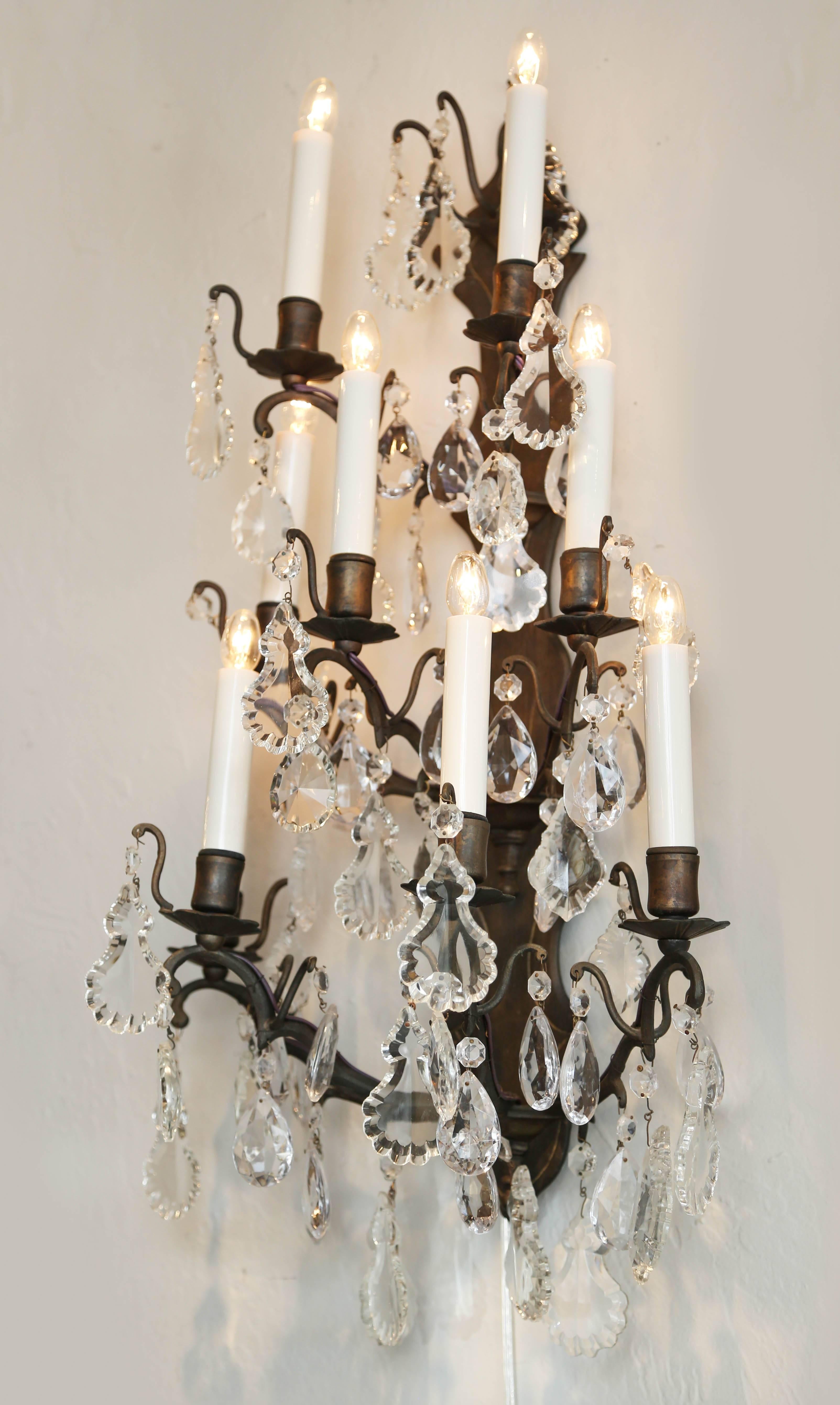 Pair of large nine-light iron and crystal French wall sconces.