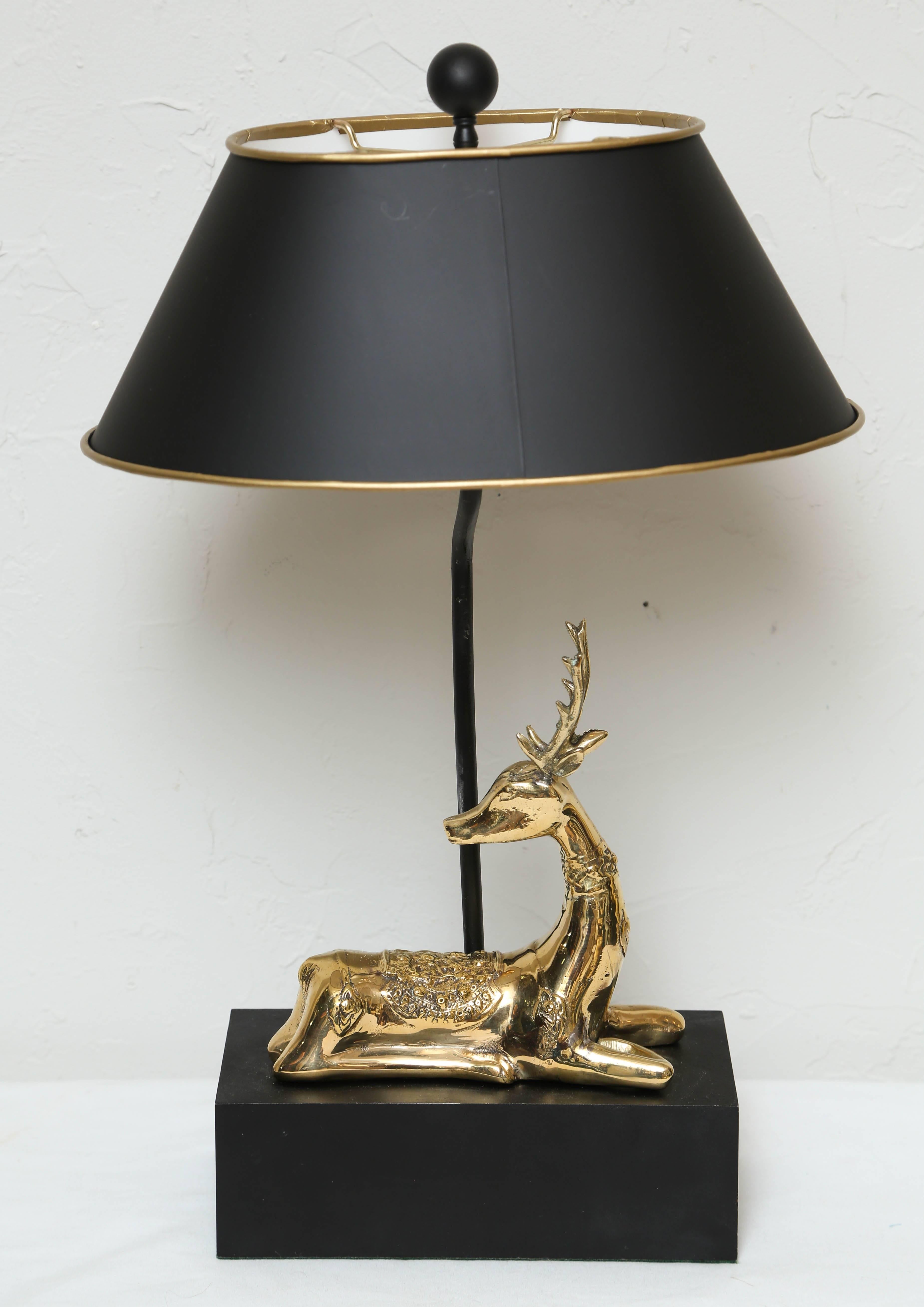 Reclining brass stag on black wood base with new oval shade.