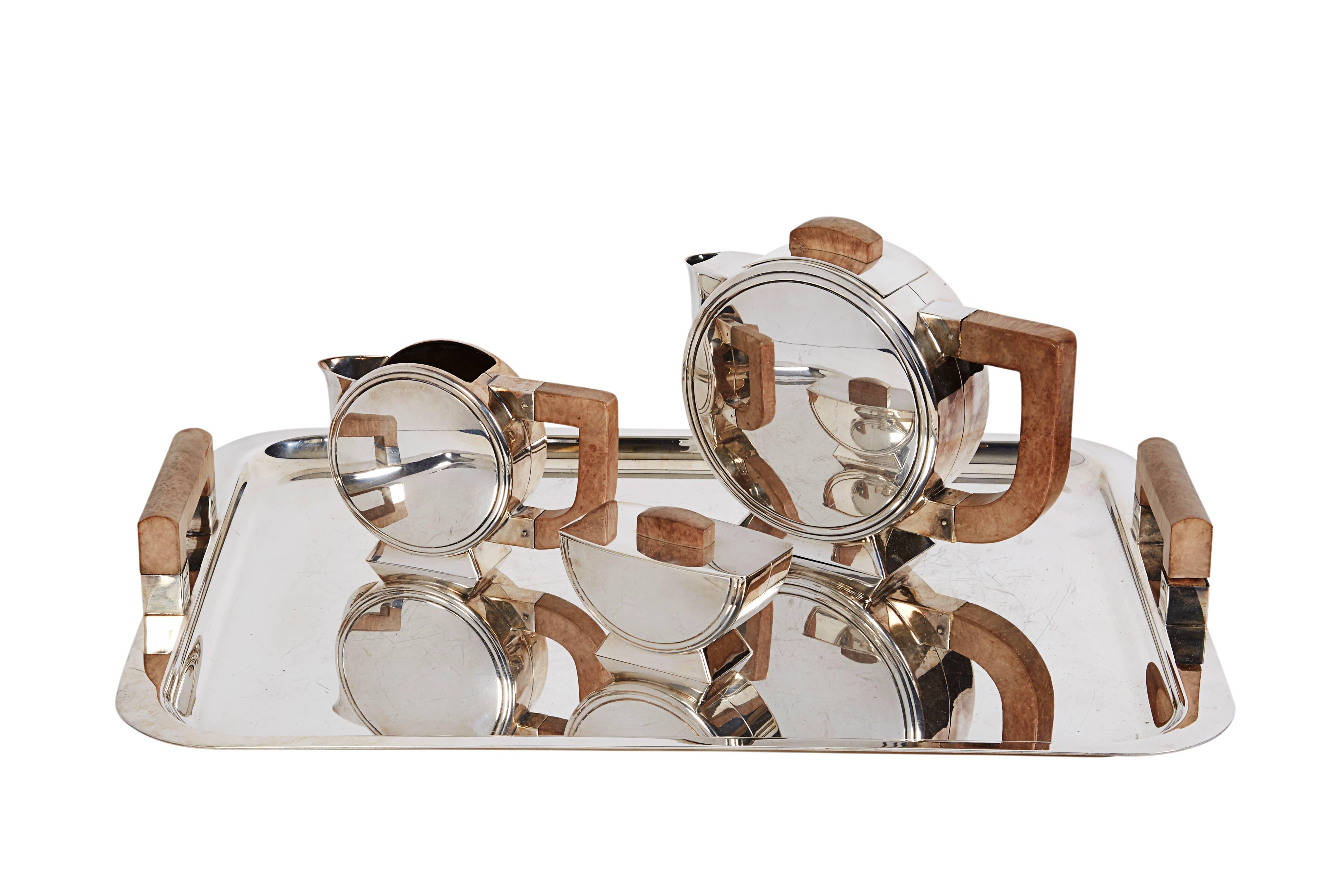 A French Art Deco silverplate and wood tea set Christofle, designed by Christian Fjerdingstad. 

Paris, circa 1920

Comprising a teapot, creamer, sugar and a two-handled serving tray.

Width of tray 19.5 inches

Good condition, normal