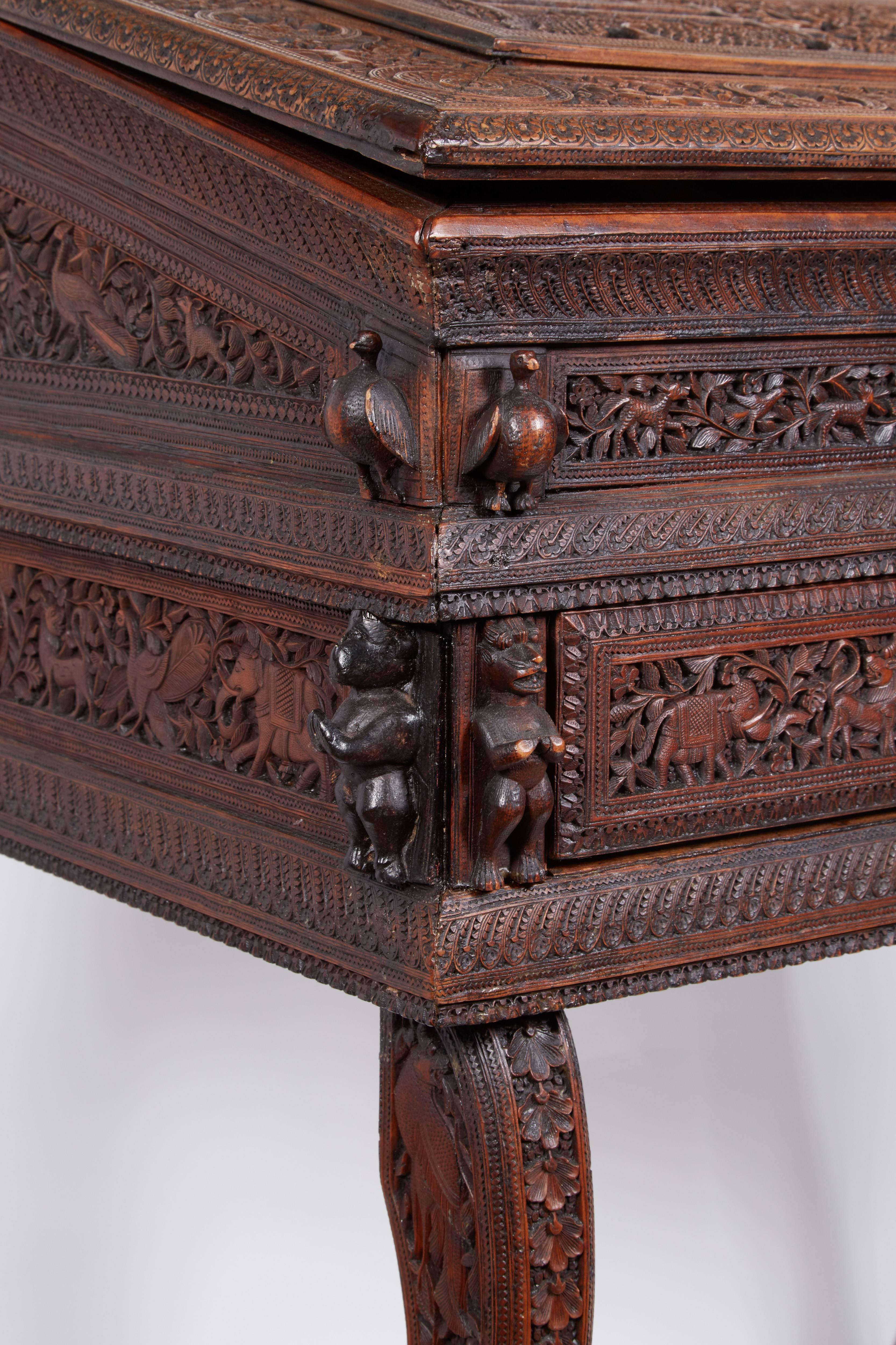 An exquisite Anglo-Indian sandalwood carved writing desk Mysore, South India

19th century.

Very highly detailed and carved wood scenes, depicting figures, deities, buildings and animals, et on paw feet, with two drawers.

Measures: 33