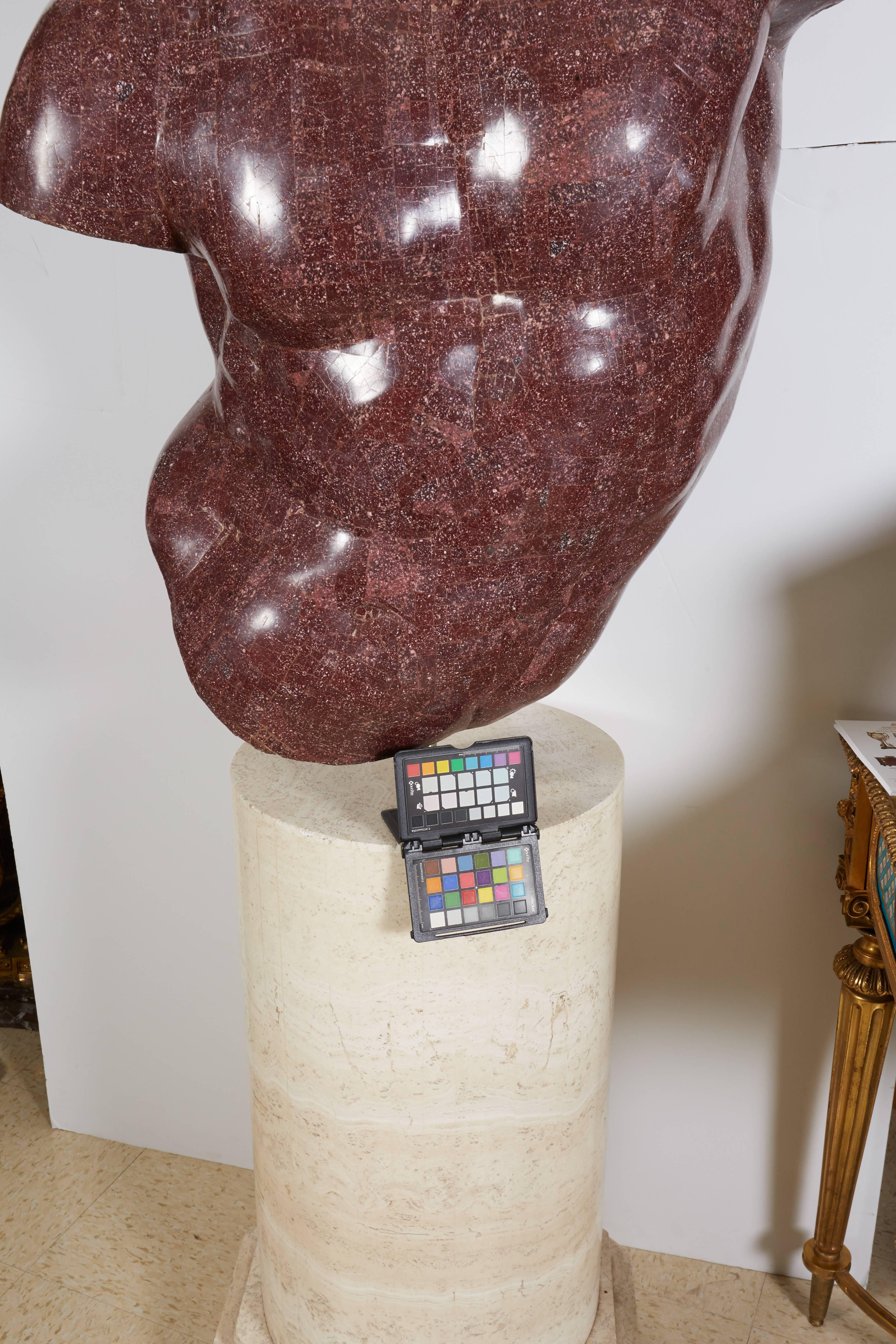 An Italian porphyry veneered model of a torso, after the antique by Anthony Redmile on marble-veneered pedestal.

20th century.

Sitting on a marble veneered pedestal turning 360 degrees.

Measures: 30.5