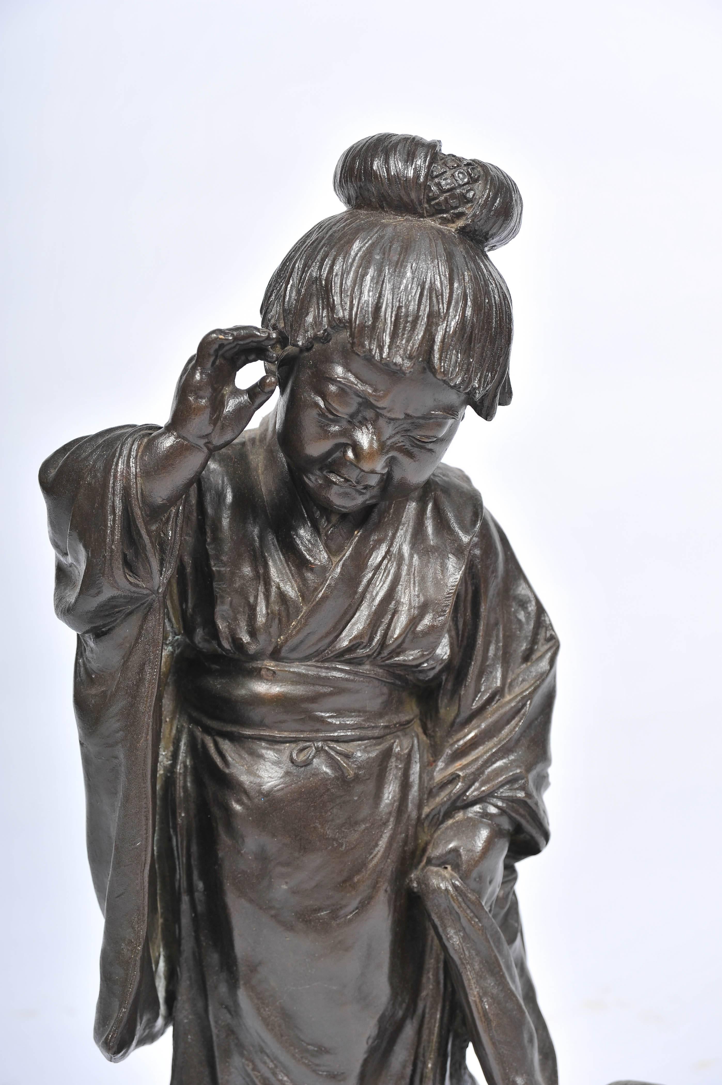 Figura in bronzo del periodo Meiji (1868-1912) di ottima qualità raffigurante una giovane ragazza che gioca con un cane. Con una buona patinatura e un timbro di firma.