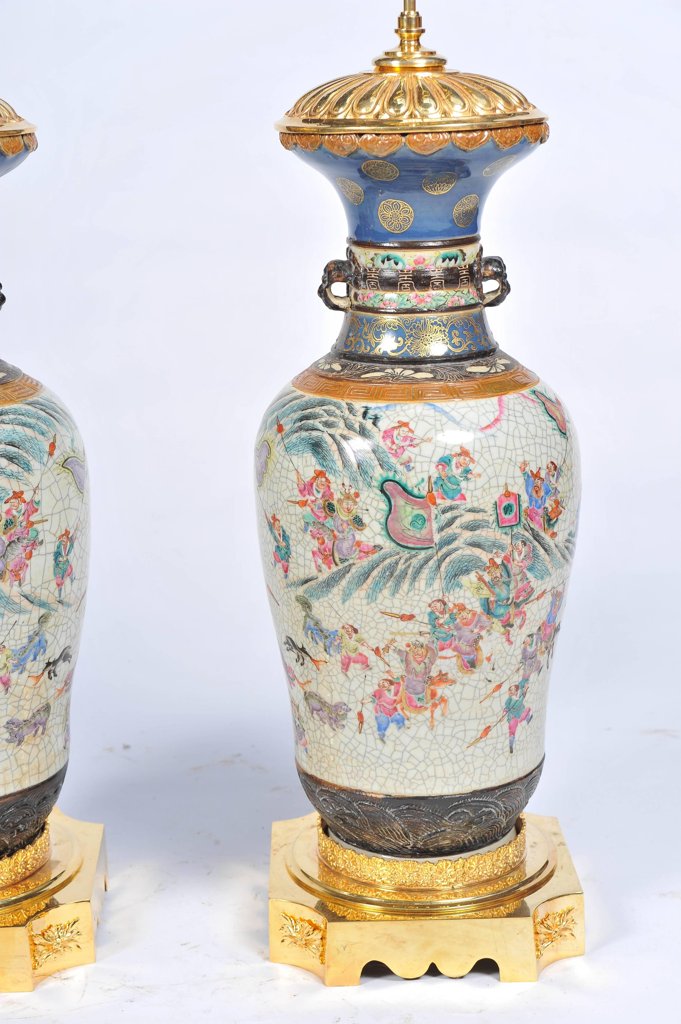 A very impressive pair of 19th century Chinese crackleware famille rose vases or lamps. Having wonderful hand-painted scenes depicting warriors fighting some on horse back, waving flags. Mounted on gilded ormolu bases and tops.