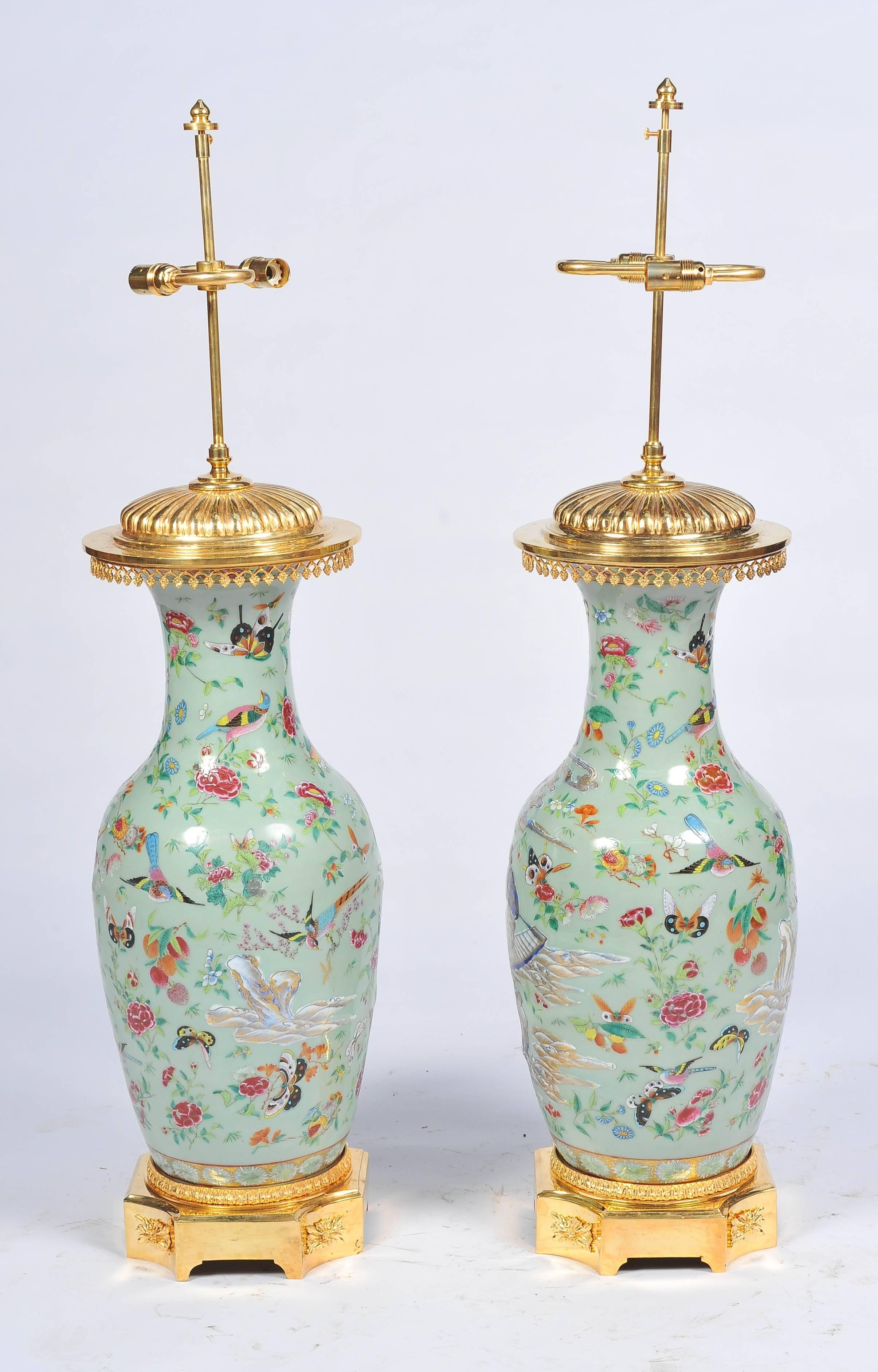 A very good quality pair of Chinese 19th century celadon, famille rose vases / lamps. Having scenes of exotic birds, flowers and fishermen in boats. Mounted on gilded ormolu bases and tops.